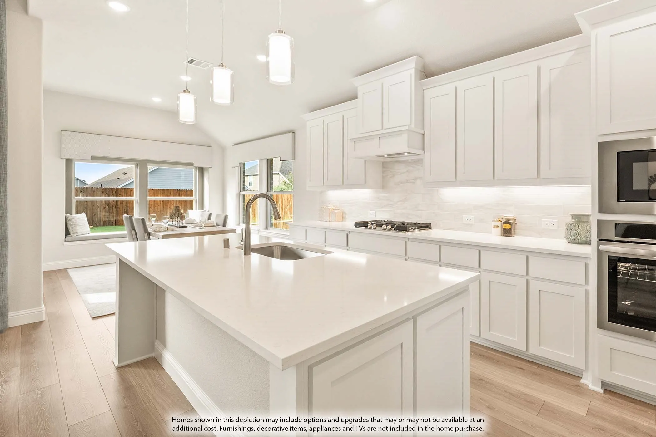 Spacious kitchen featuring white cabinetry, light-toned wood-finish flooring, and a large central island with an undermount sink