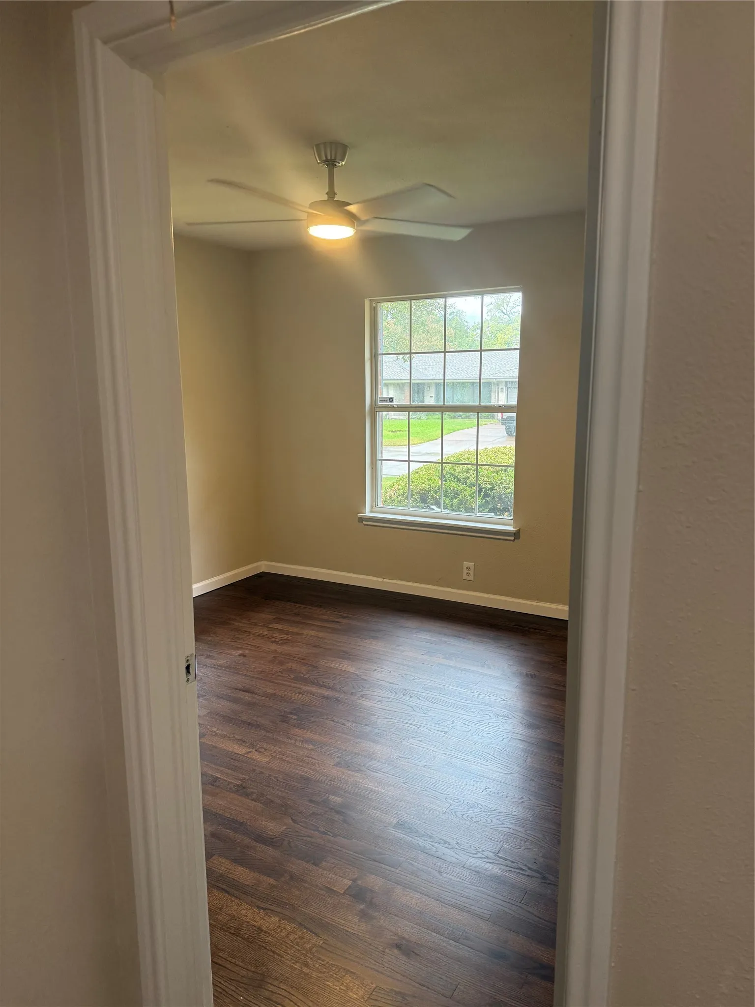 Recessed window with white trim, wood-finish flooring, ceiling fan with integrated lighting, and neutral wall paint
