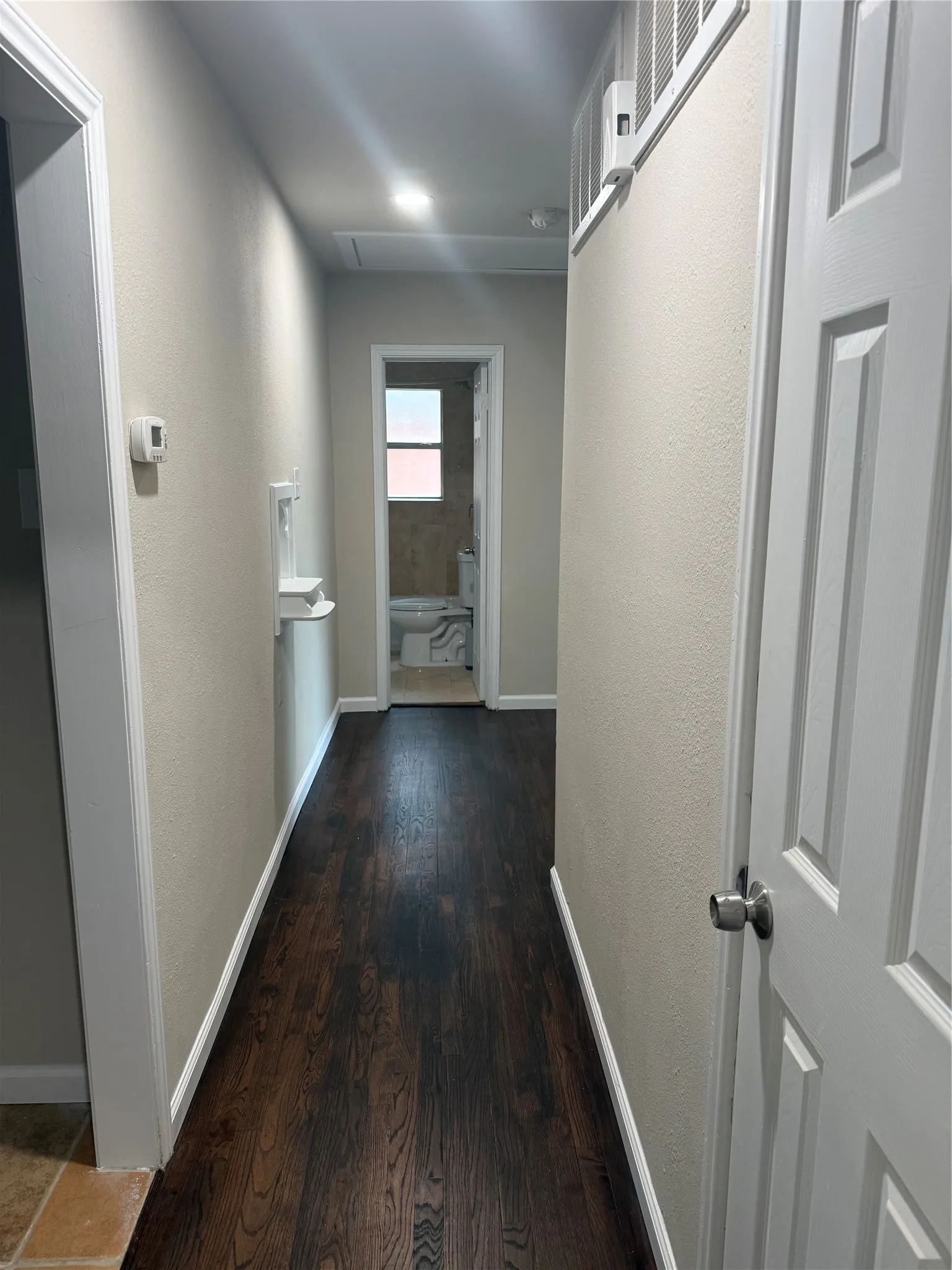 Dark wood-finish flooring extending through the hallway