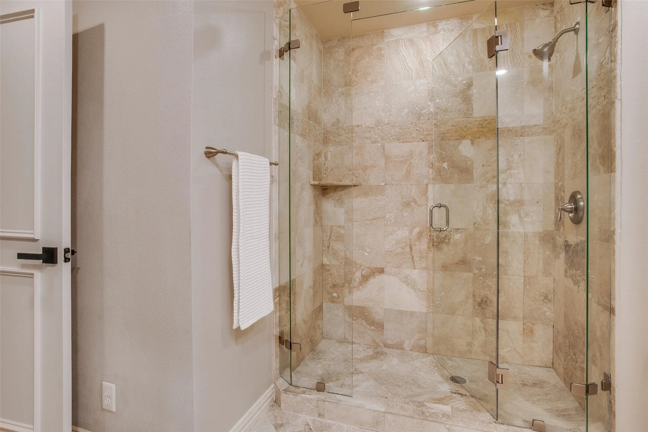 Primary Bath features an oversized glass-enclosed stone shower.