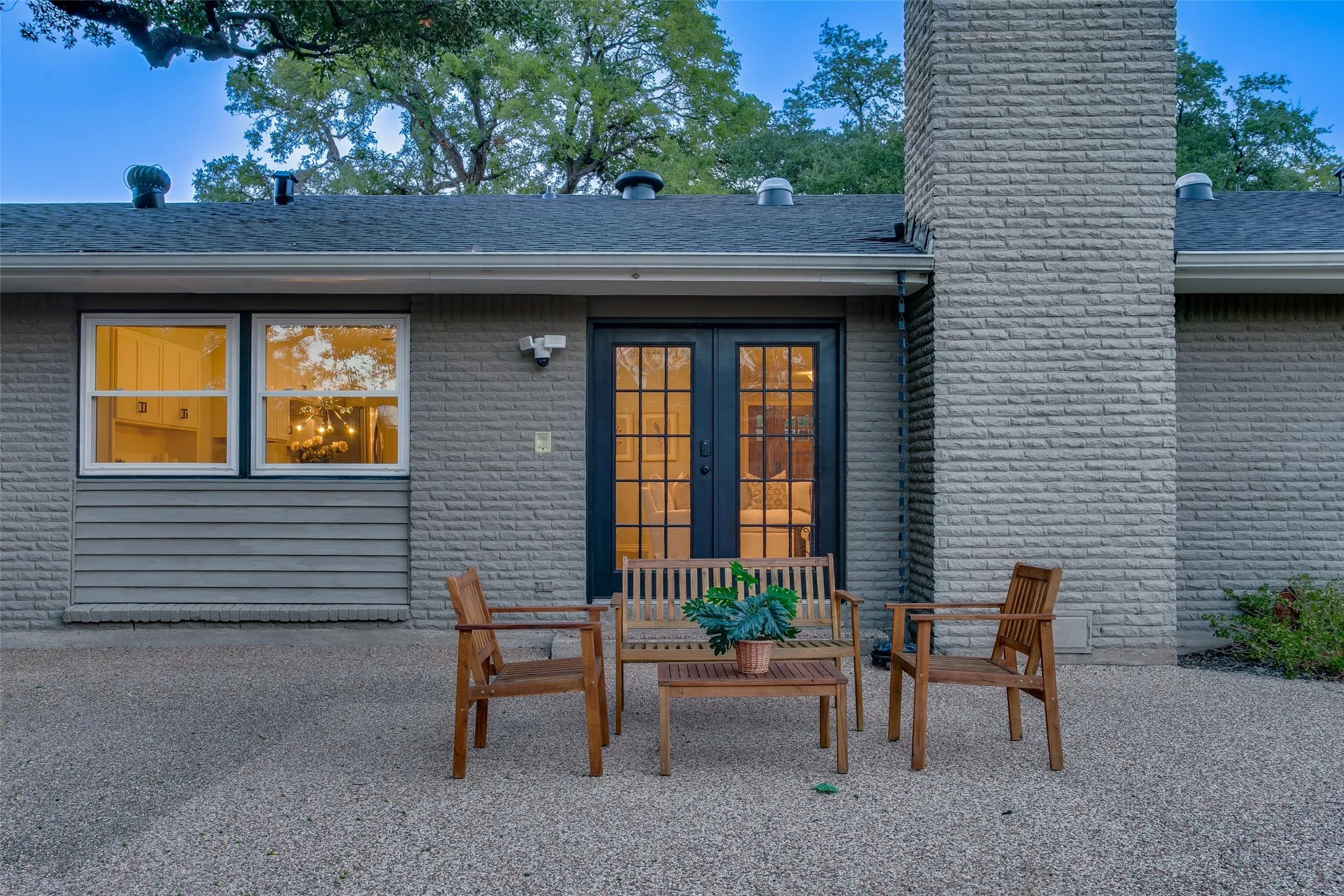 Back patio framed by the home's Mid-Century architecture and mature oak canopy.
