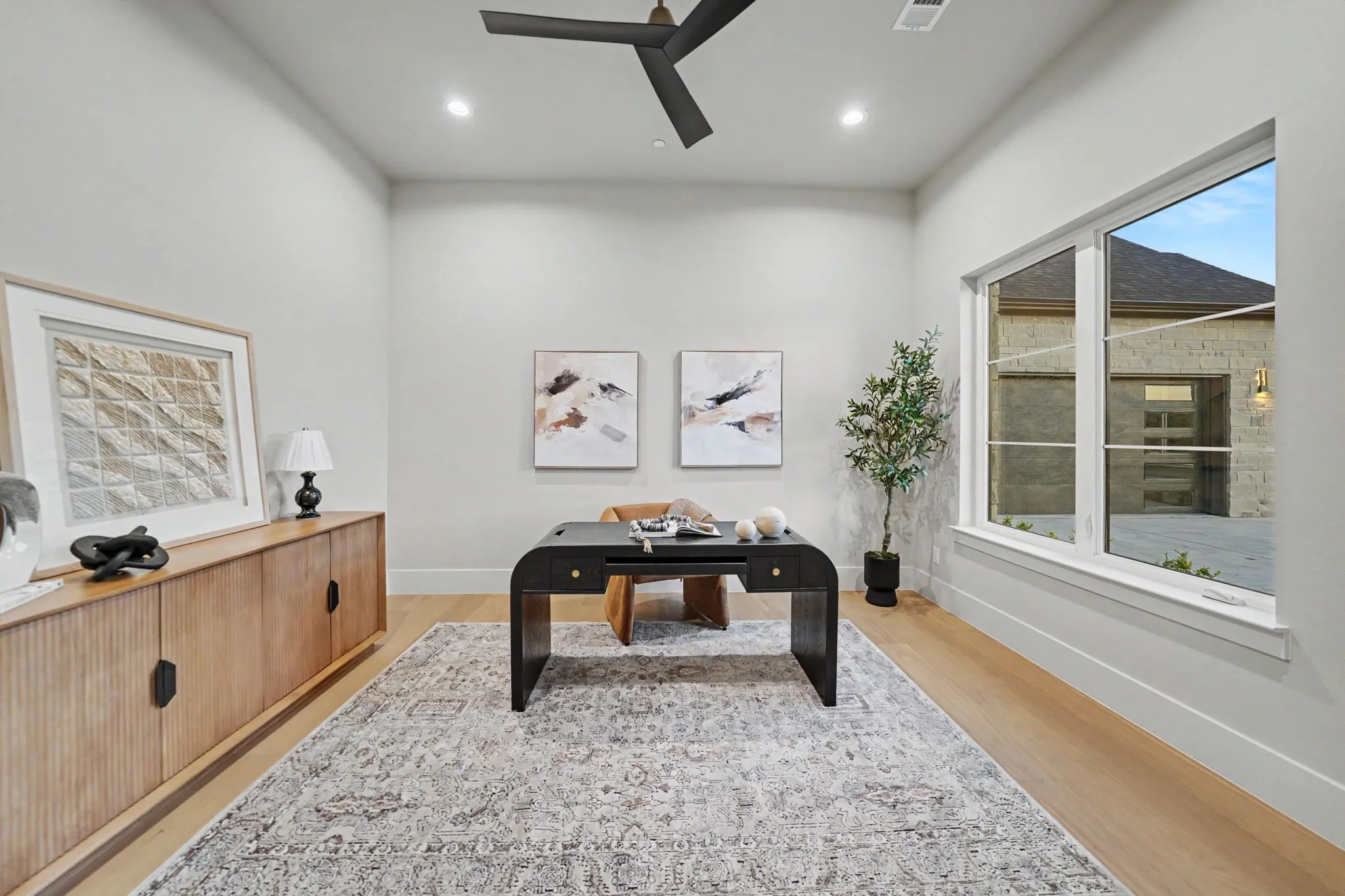 Spacious interior with wood-finish flooring, recessed lighting, and a contemporary ceiling fan