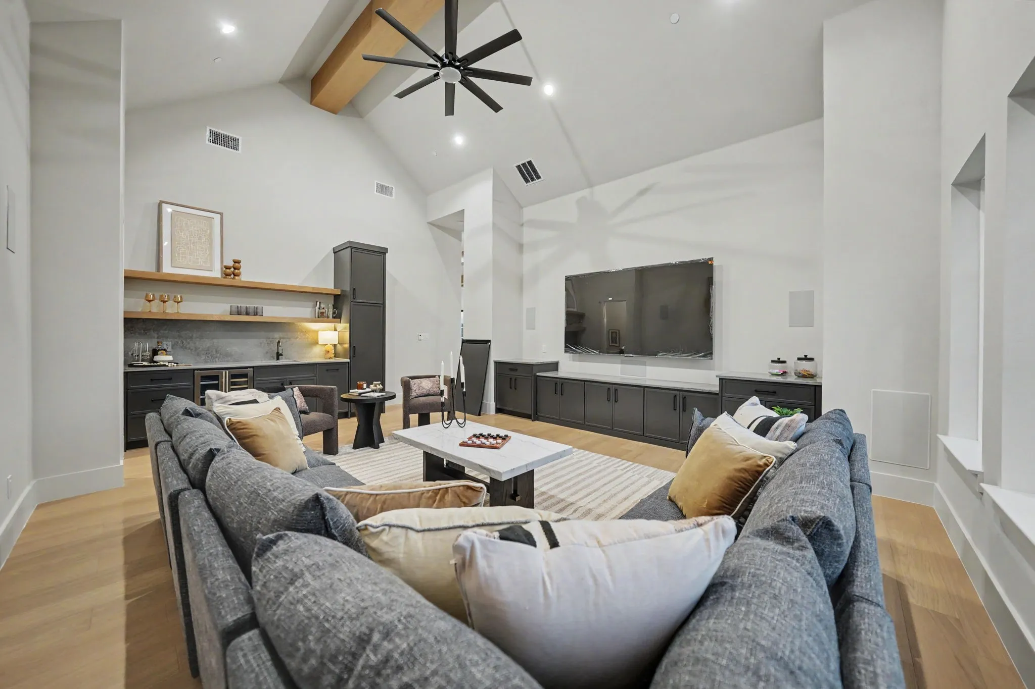 Vaulted ceiling with an exposed wood beam and ceiling fan