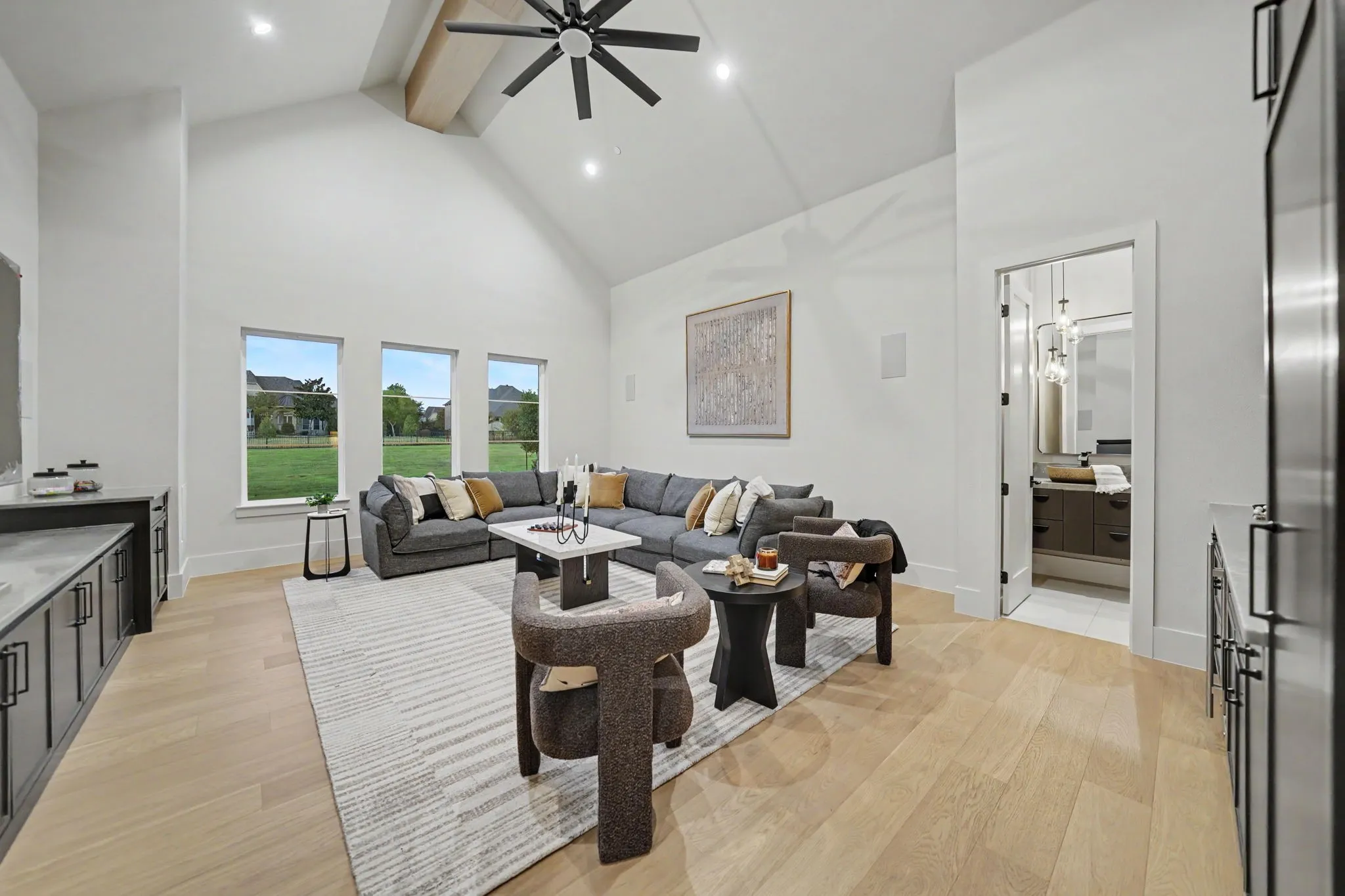 Vaulted ceiling with exposed wood beam, recessed lighting, and a ceiling fan