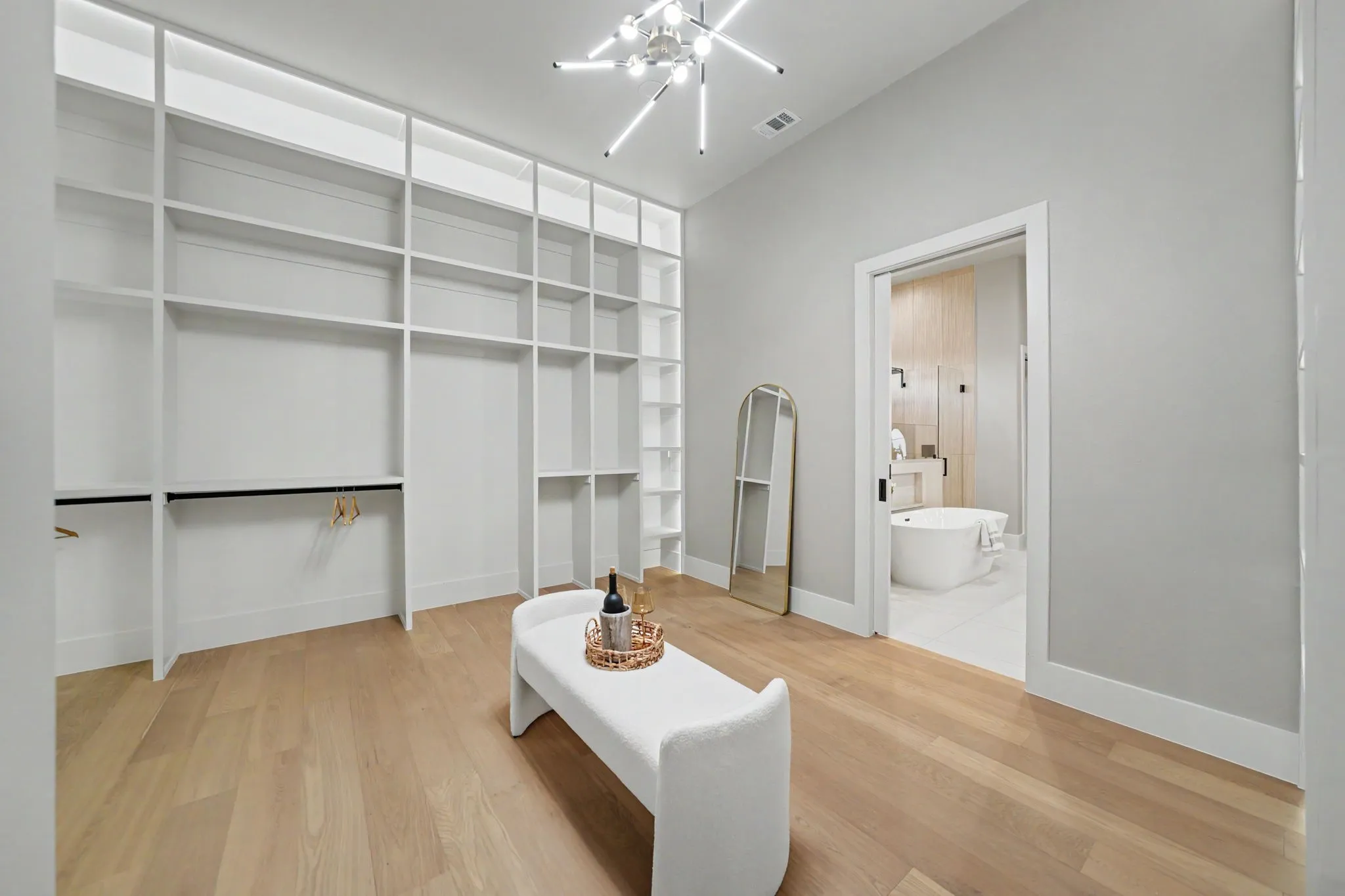 Integrated custom closet system, wood-finish flooring, contemporary chandelier, and high ceilings