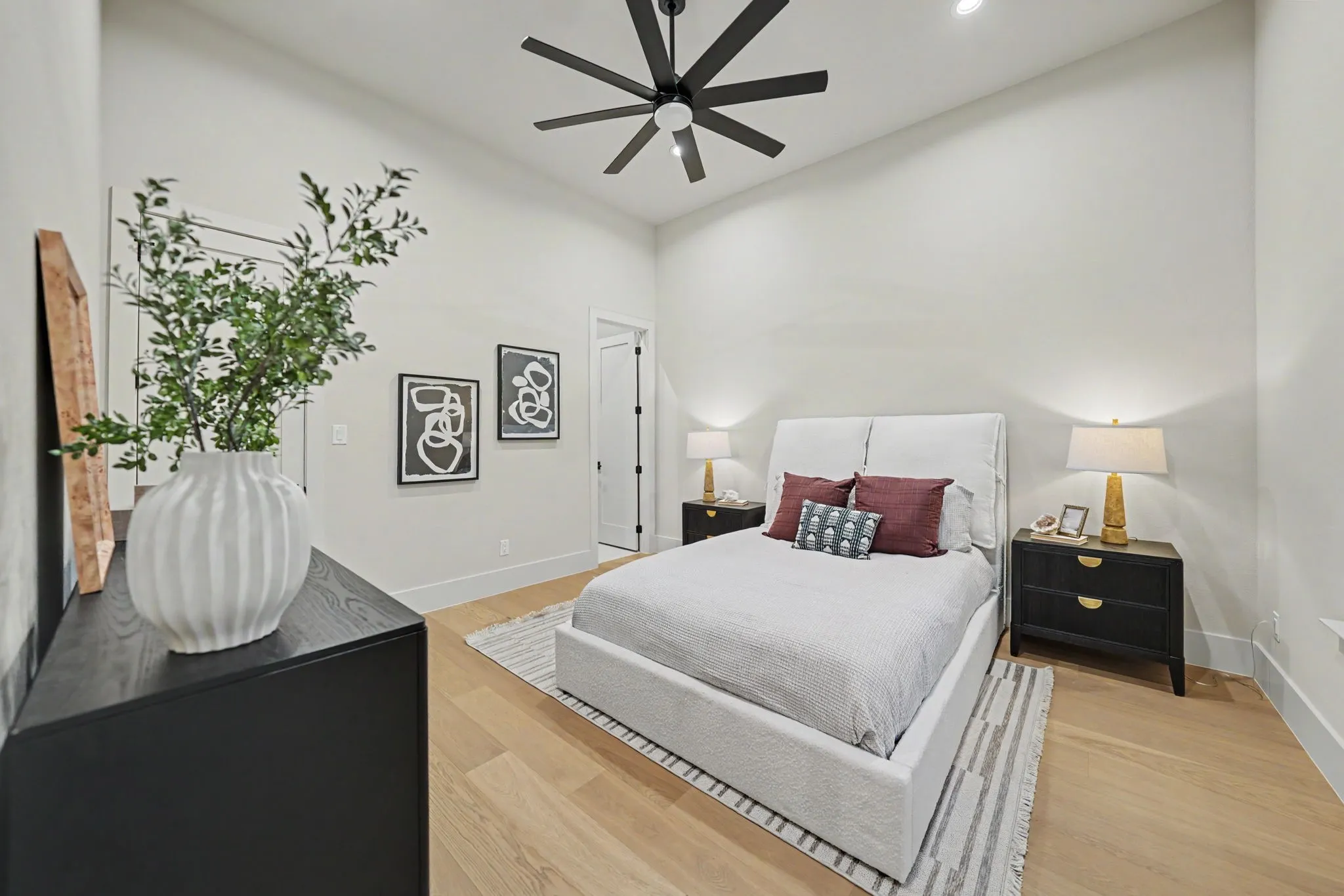 Hardwood flooring, recessed lighting, matte black ceiling fan, white walls, and white trim