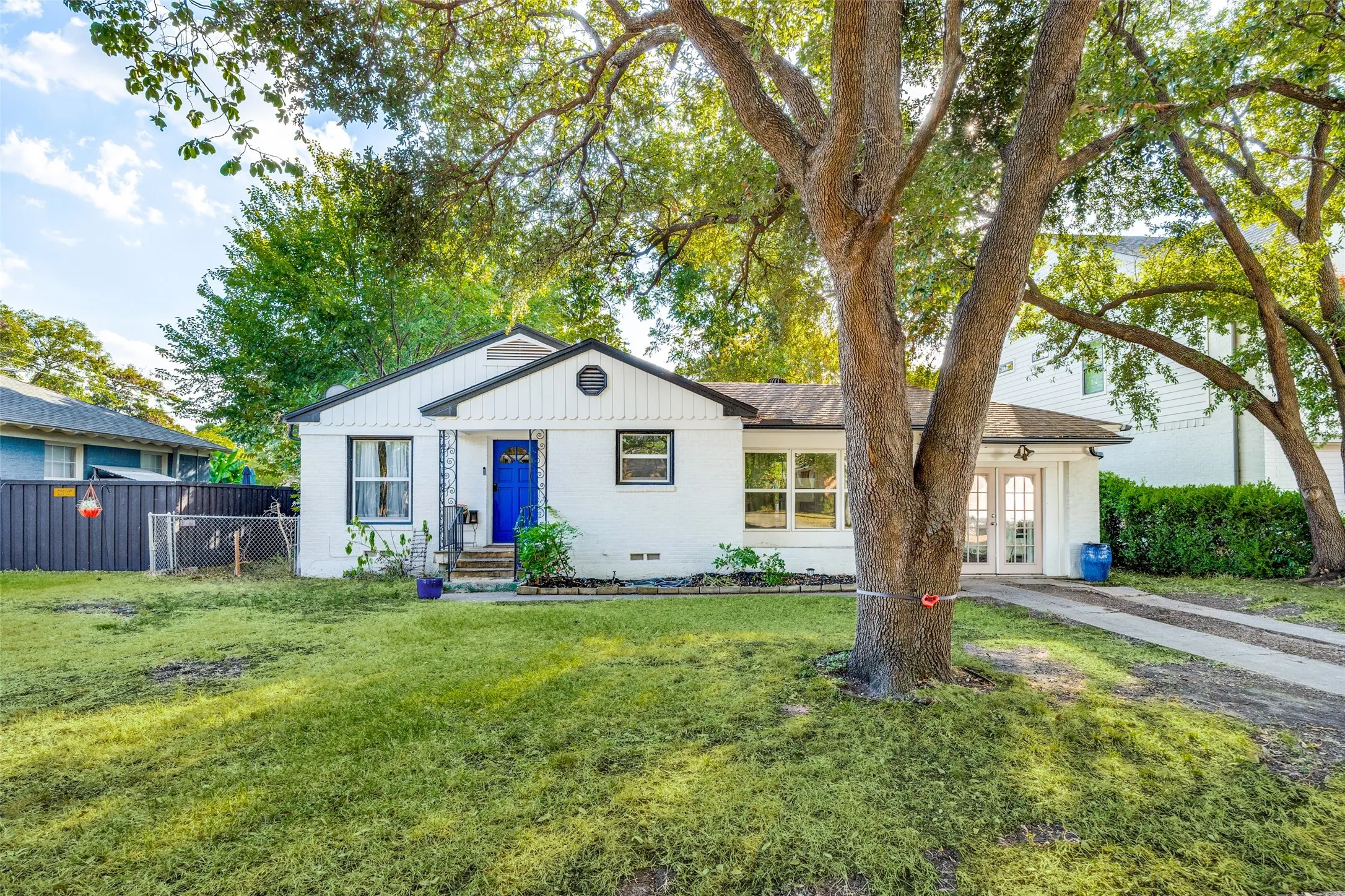 Single-story residence featuring a white exterior, black trim, and a vibrant blue entry door