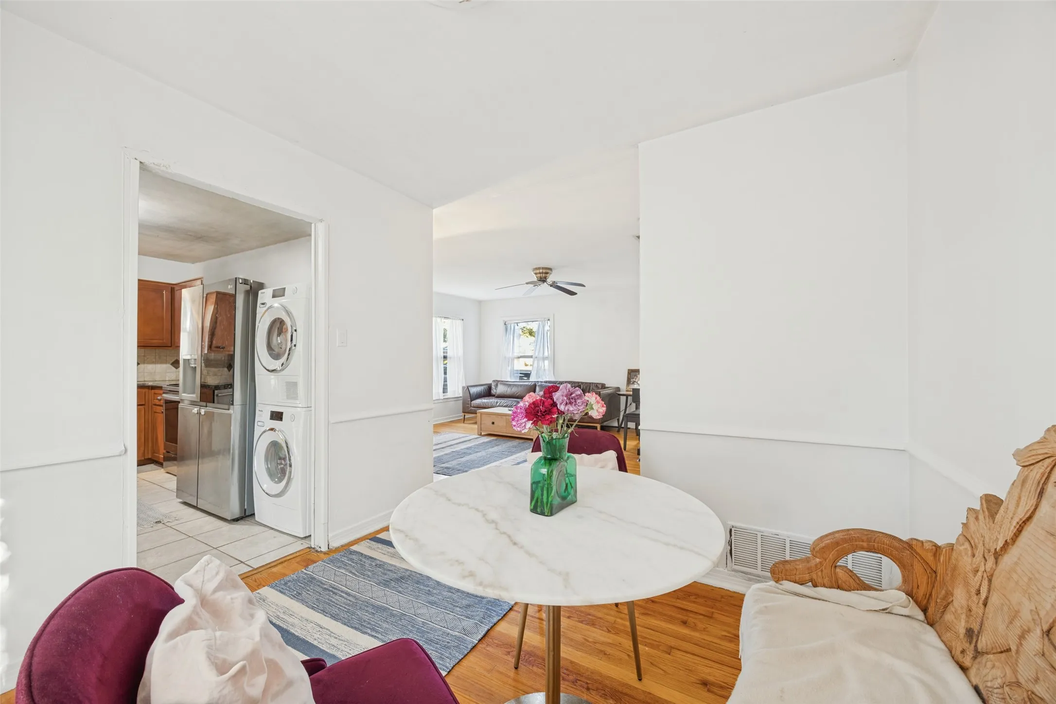 Hardwood flooring, white wall paint, wall trim, recessed ceiling, and kitchen with stainless steel appliances