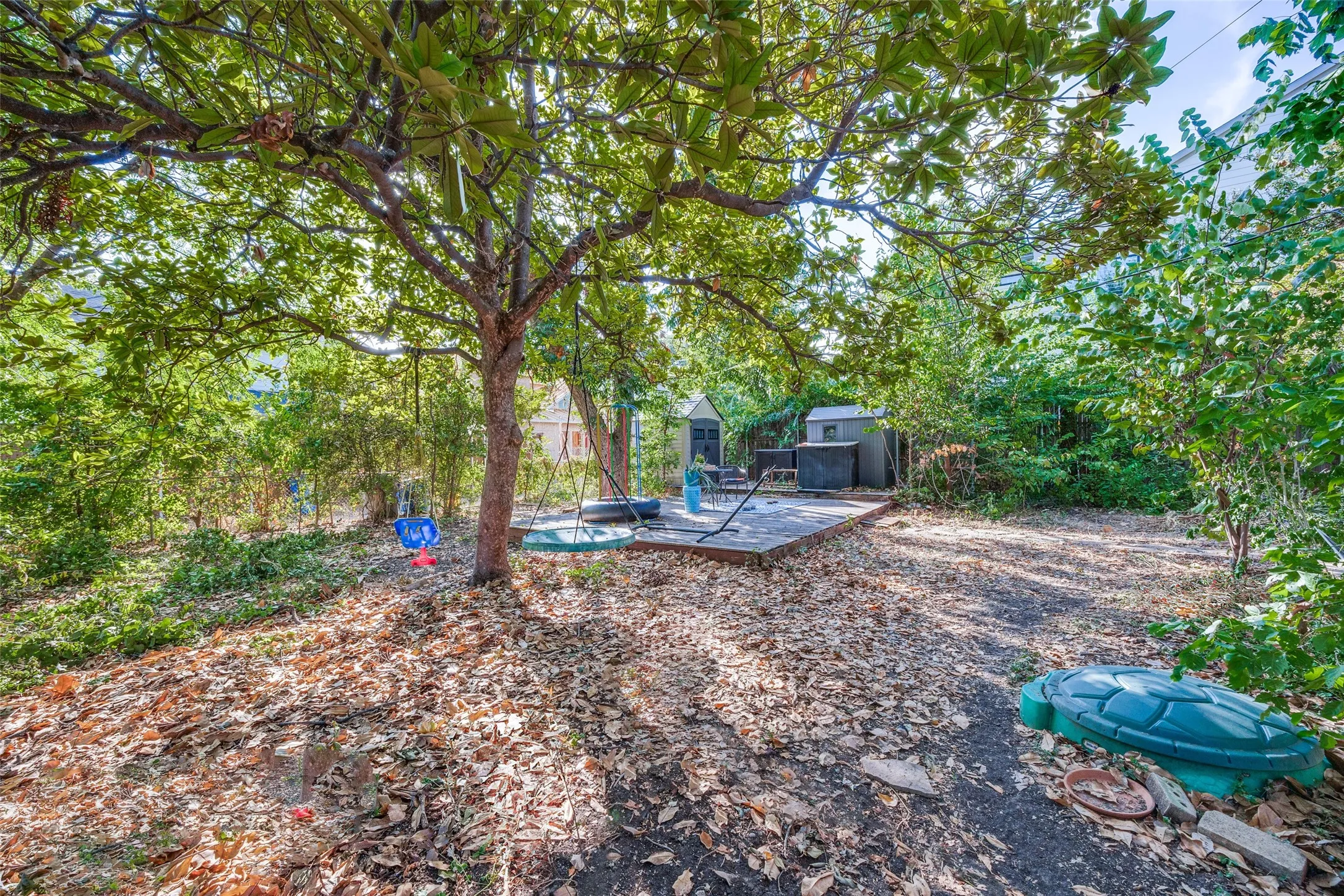 Expansive yard space featuring mature trees and a wood deck