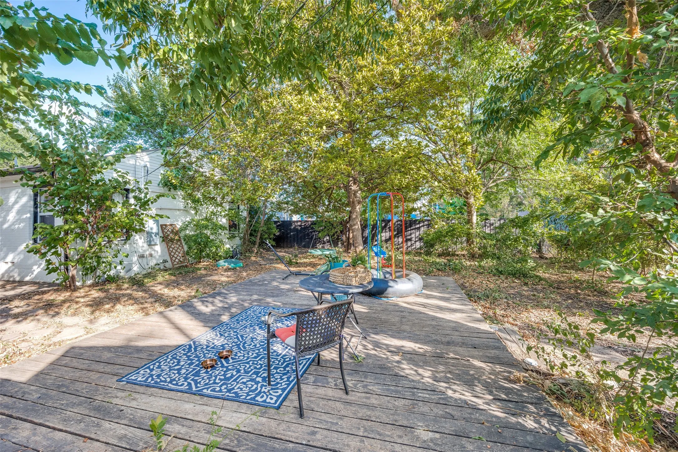 Wood-finish patio with a stone path and established trees