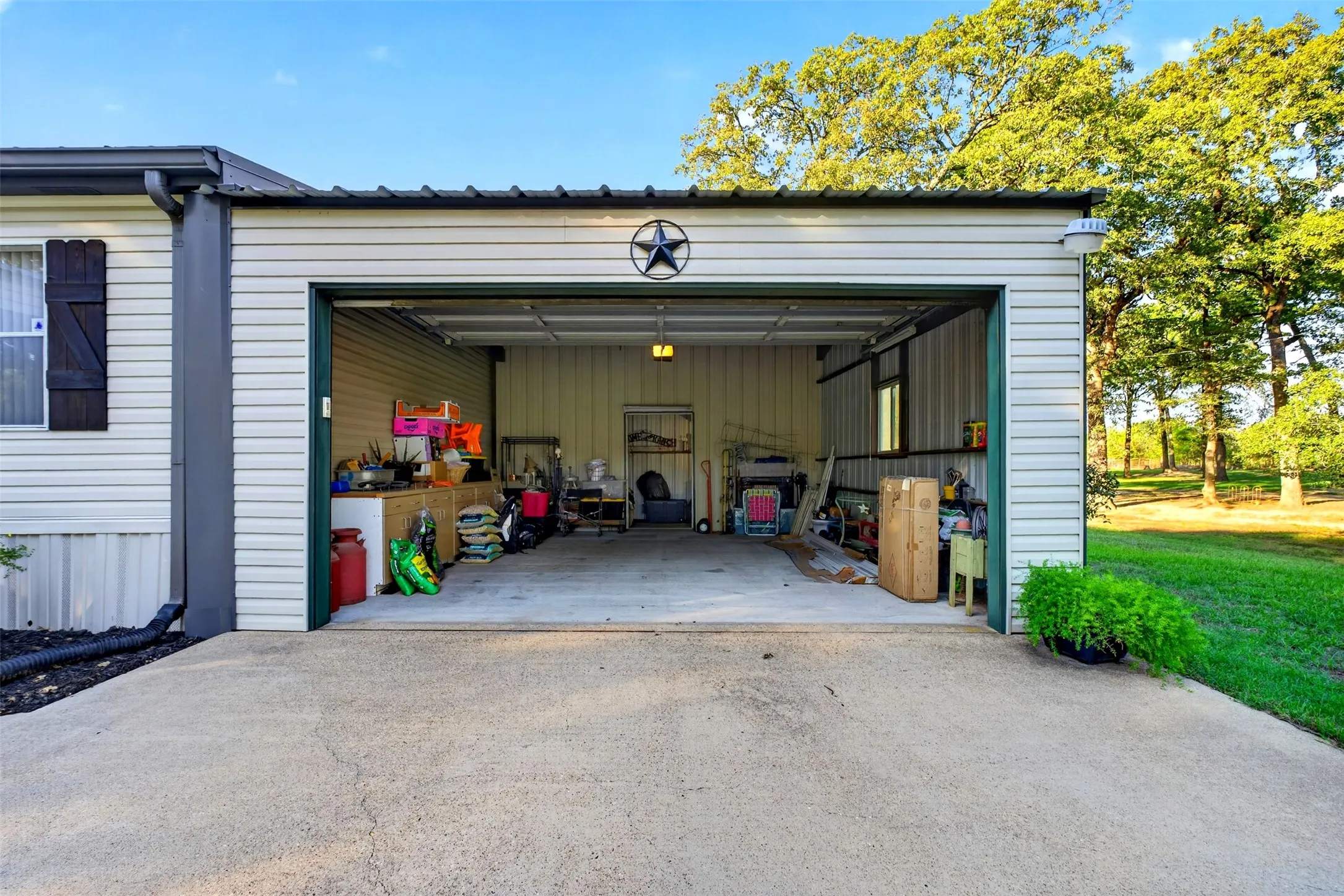 2 car garage with metal remote door, concrete pad and extra storage in back.