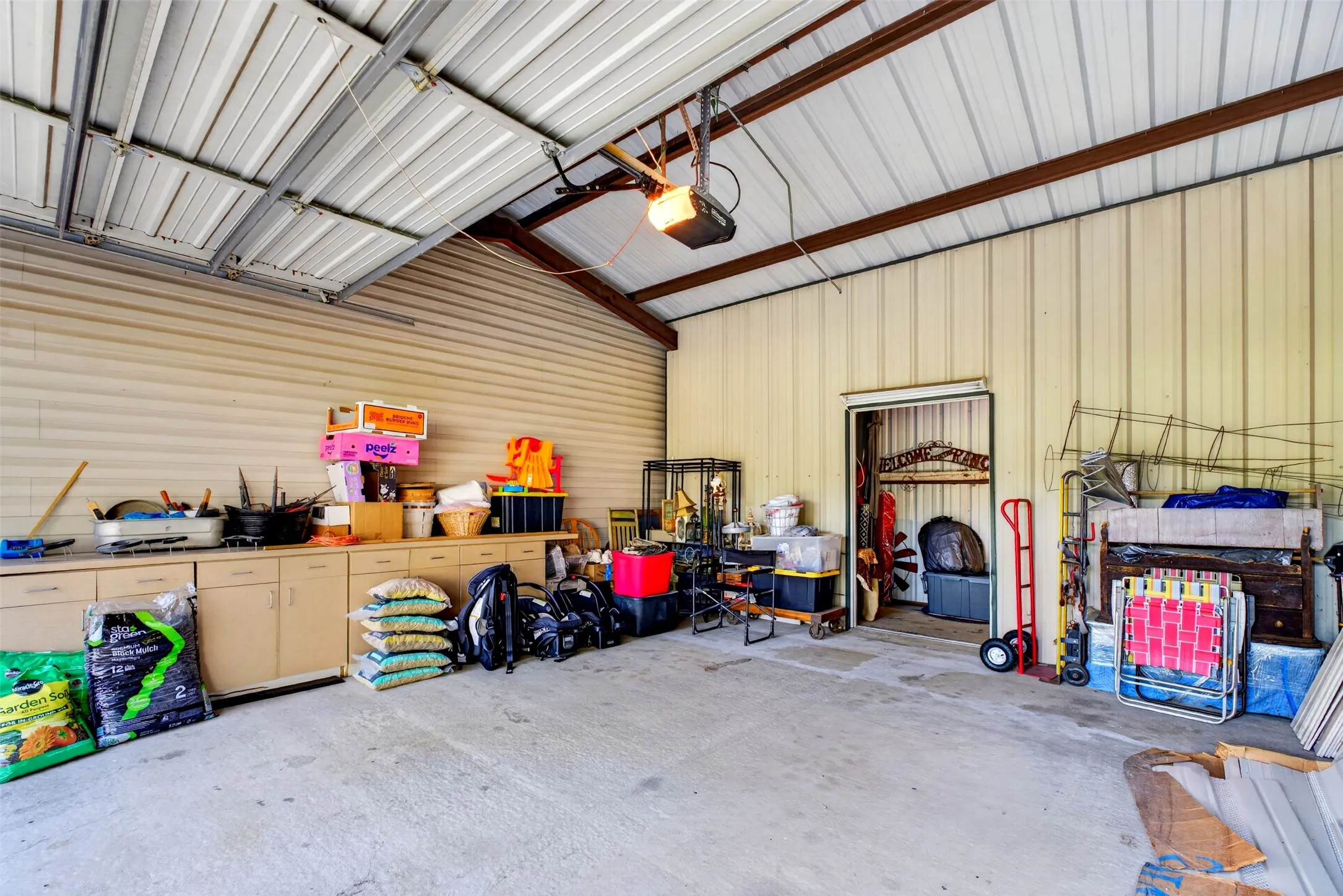Additional storage in 2 car garage with vaulted ceiling.