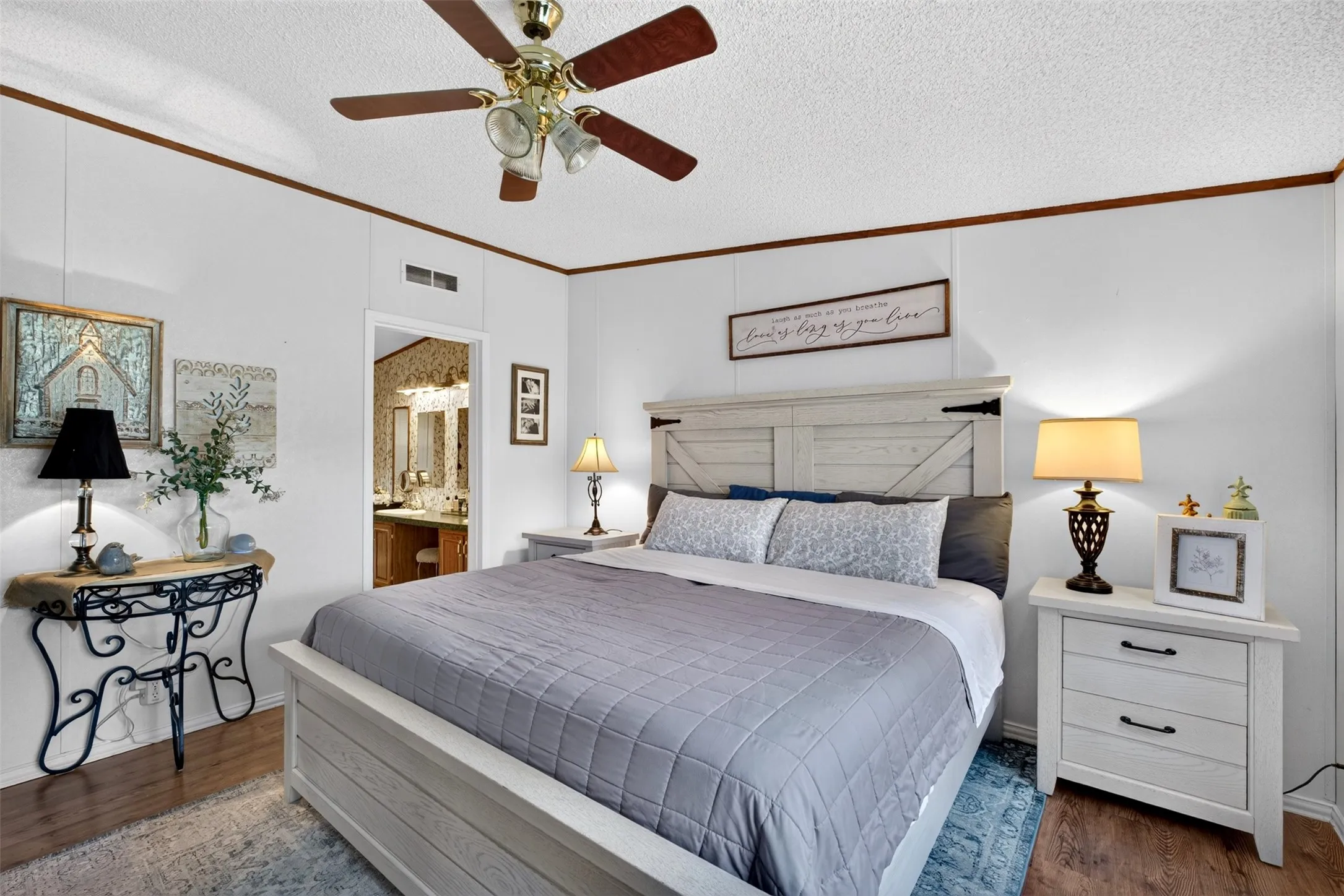 White paneled walls with wood trim, wood-finish flooring, and a ceiling fan with integrated lighting