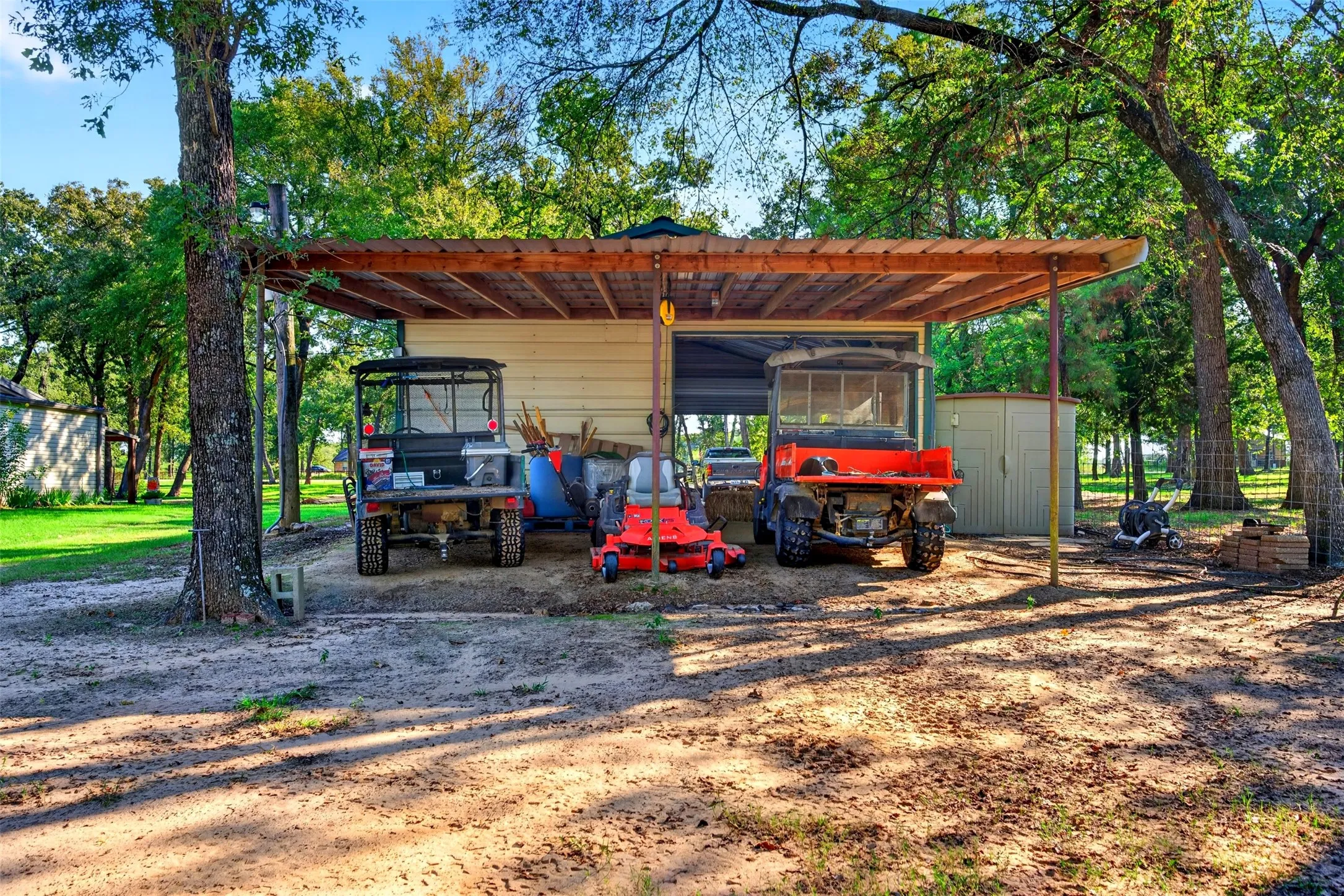 covered carport for farm machines on the back side of the Shop.