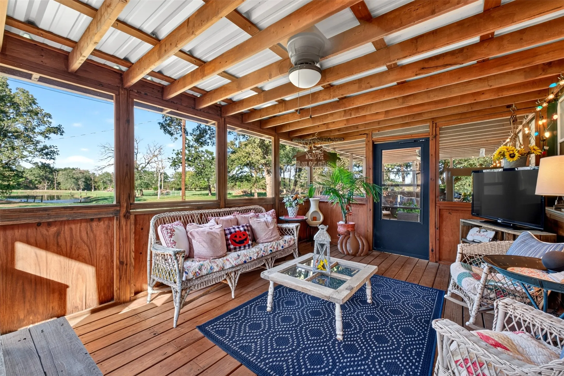 Screened in porch with amazing view of pond, a metal roof, a ceiling fan.