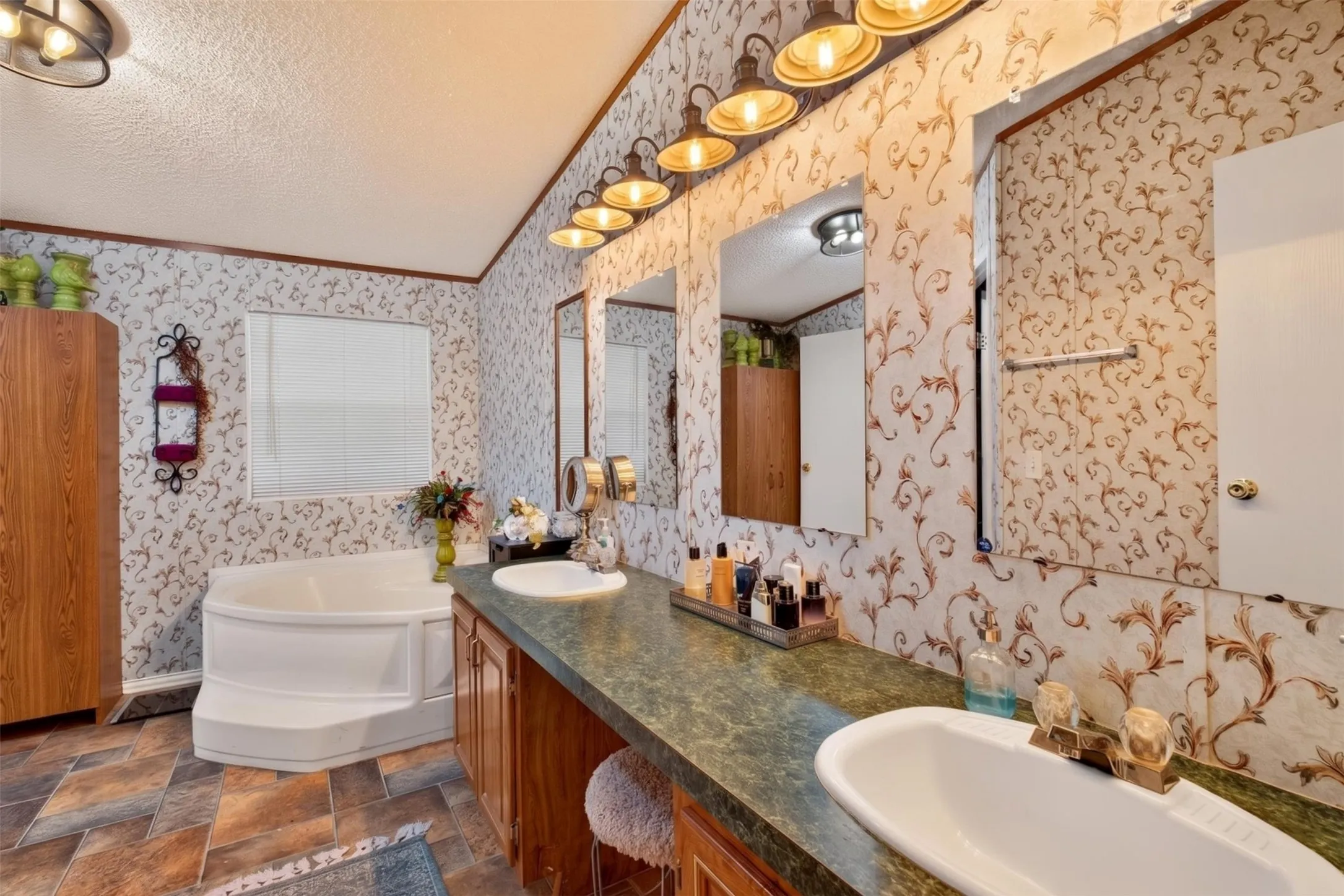 Dual vanity with undermount sinks, corner soaking tub, and tile flooring