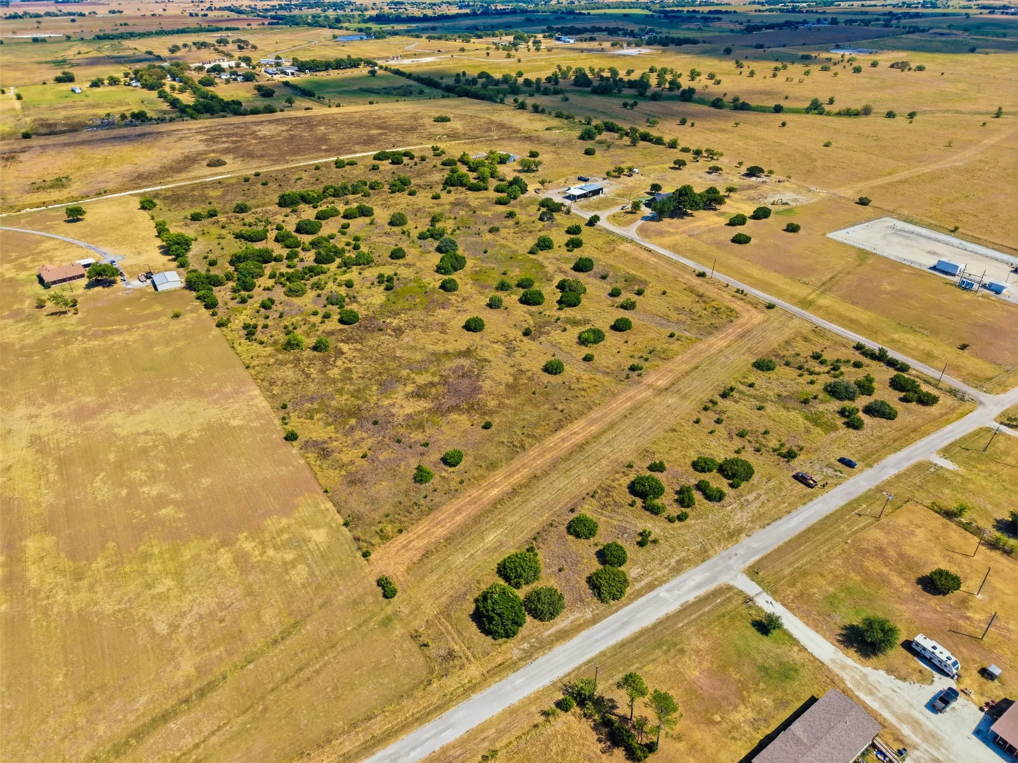 Expansive undeveloped land featuring scattered vegetation and clear land divisions