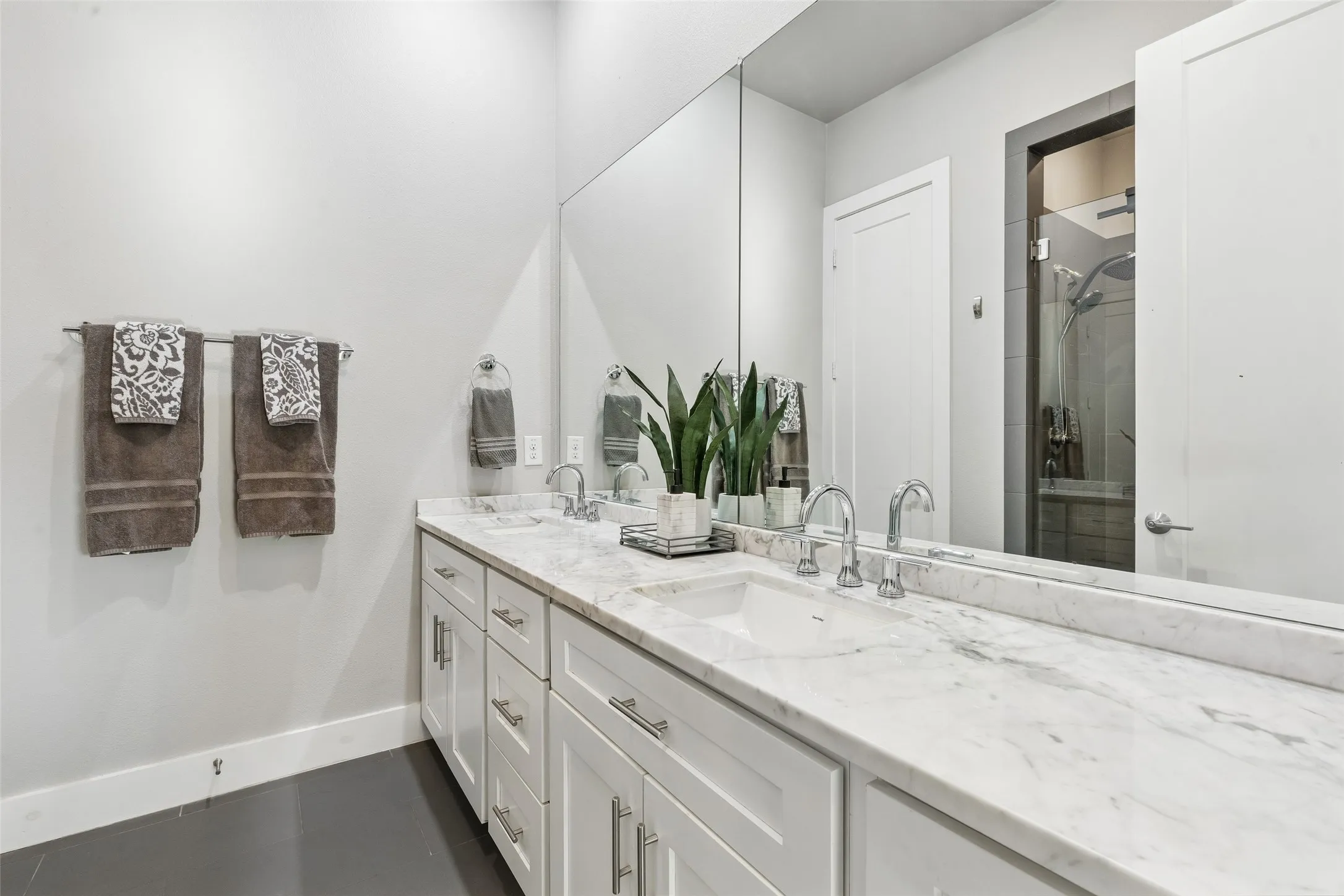 Double vanity featuring a light-toned countertop, dual undermount sinks, and chrome faucets
