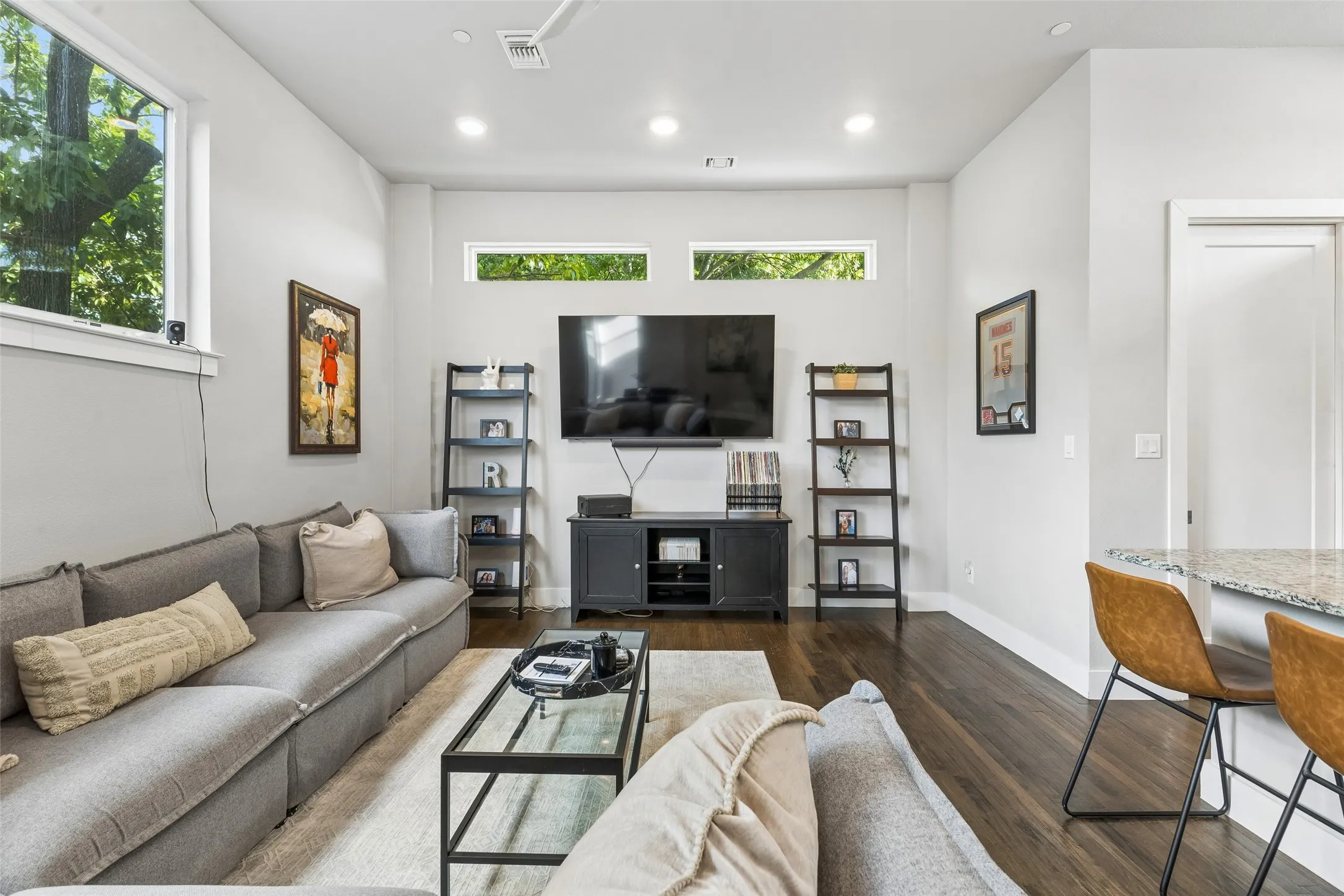 Hardwood-style flooring throughout, recessed ceiling lighting, high ceilings, large windows, and transom windows