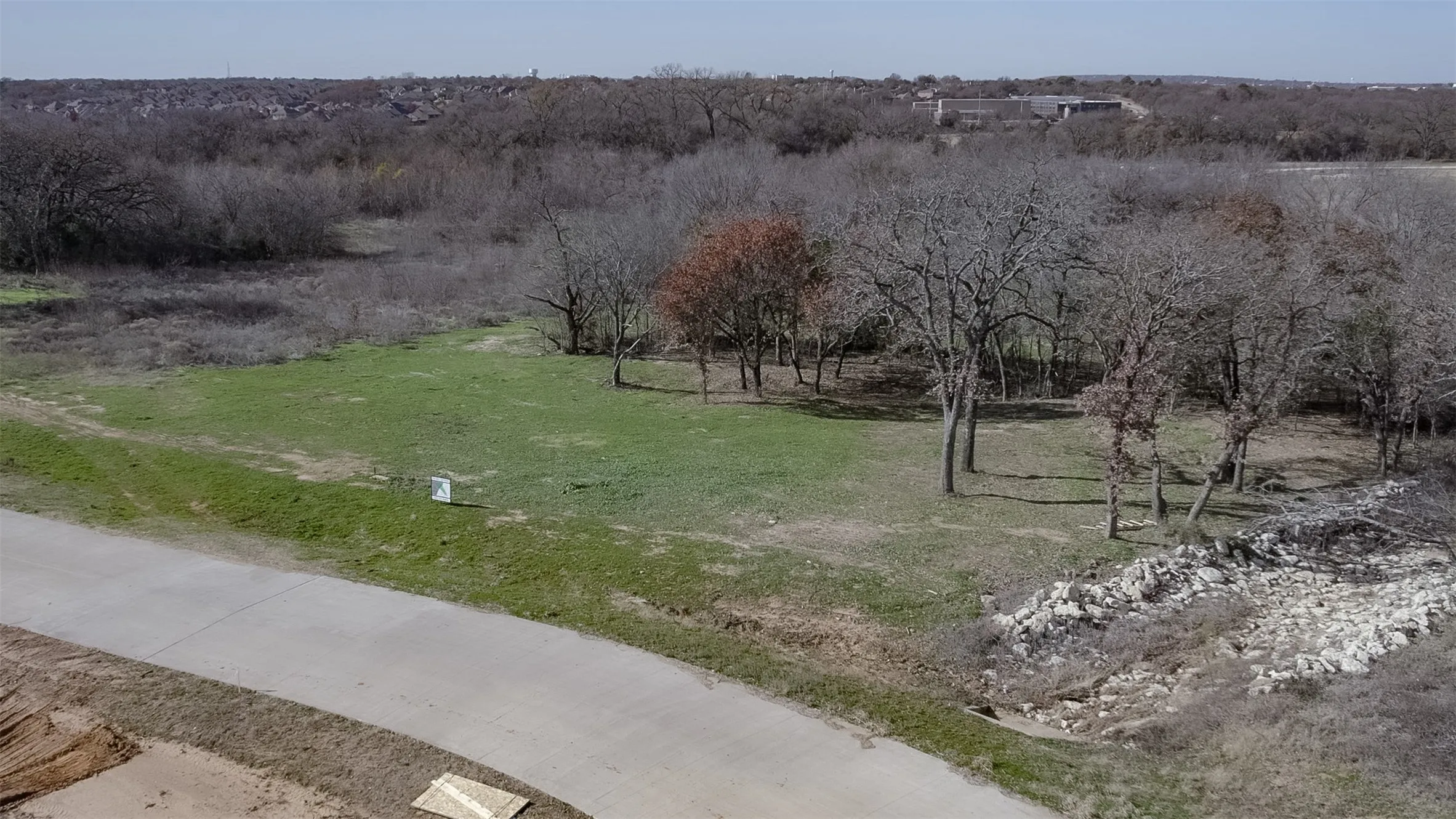 Paved road frontage, established tree coverage, and open grassy areas