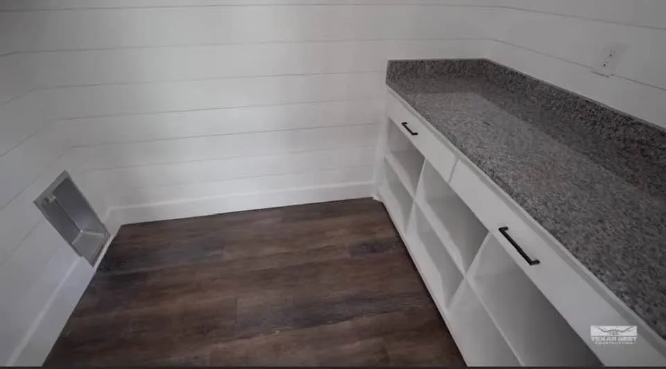 Separate laundry room on first floor features storage bins and folding area.