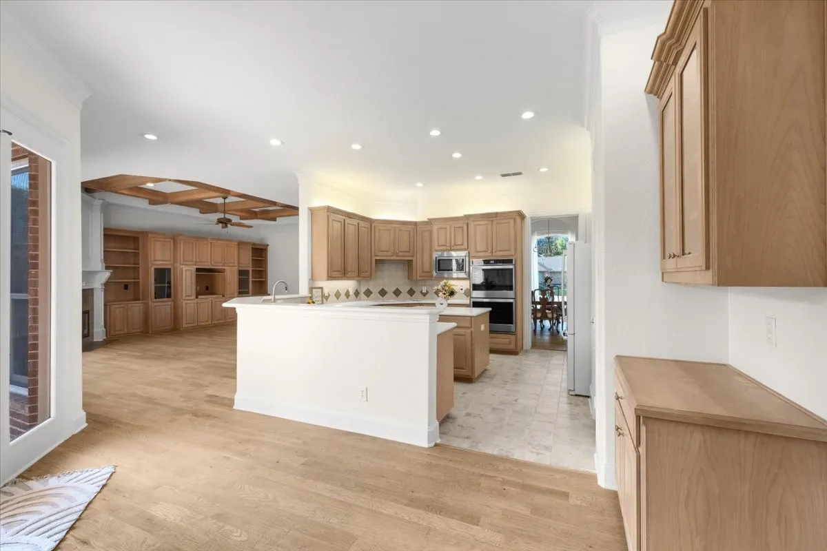 Kitchen featuring light wood-finish cabinetry, stainless steel appliances, and a central island