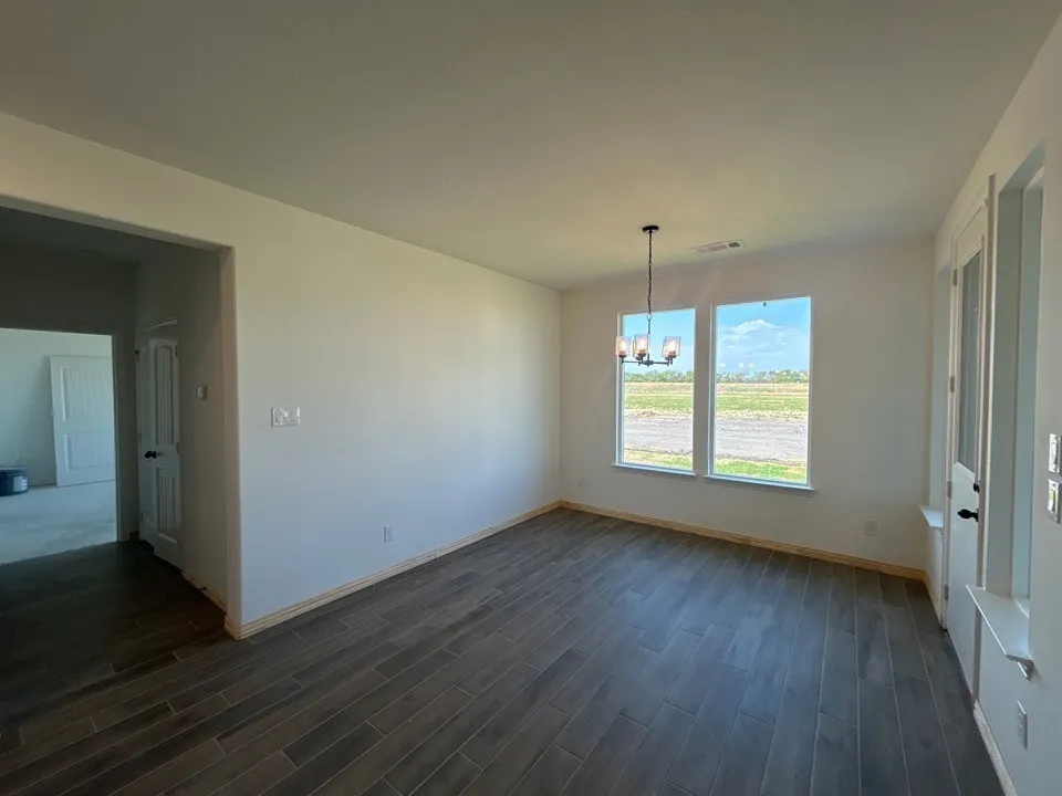Wood-finish plank flooring, large windows, ceiling-mounted light fixture, white interior doors