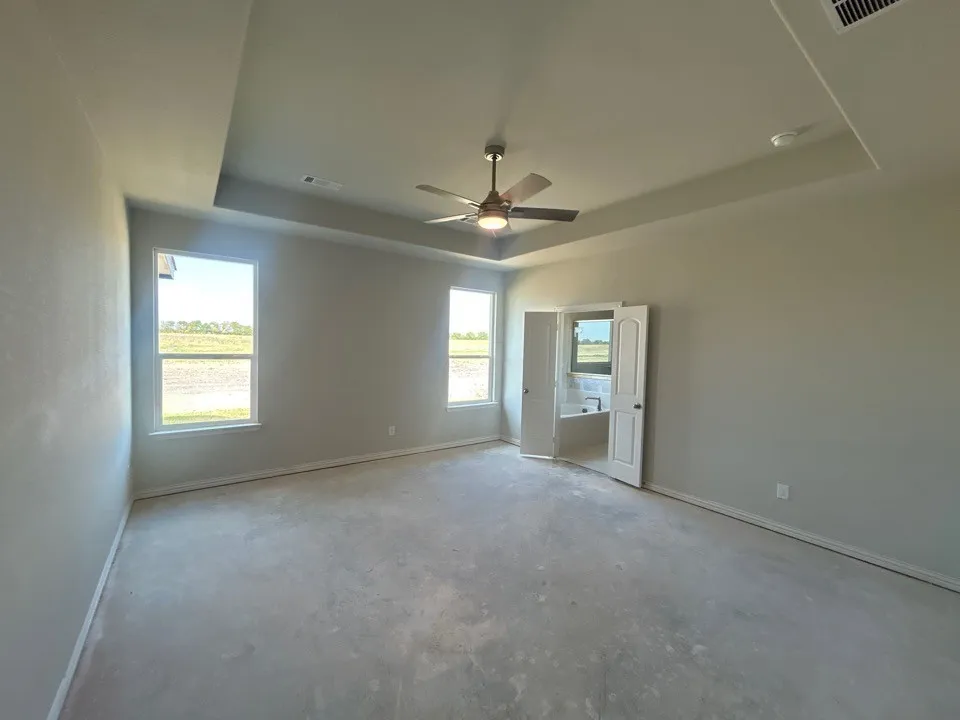 Spacious room with a tray ceiling and ceiling fan