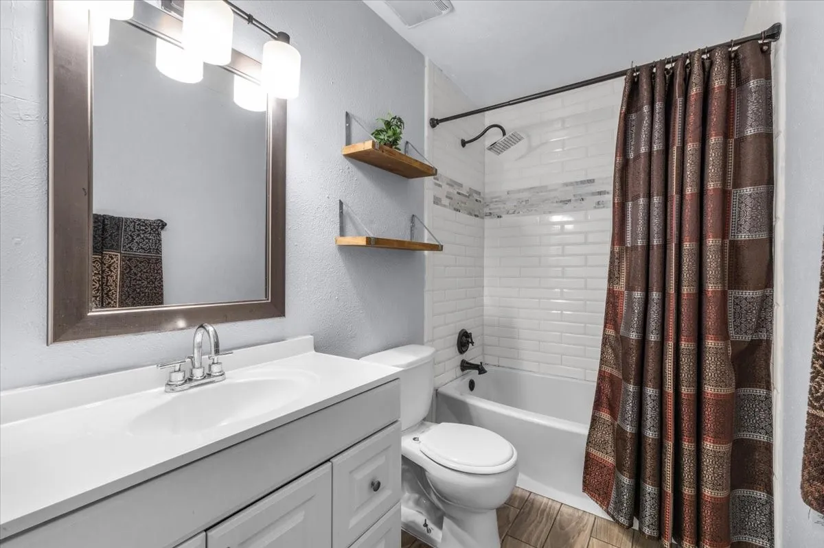 White vanity with integrated sink, framed mirror, and contemporary light fixture