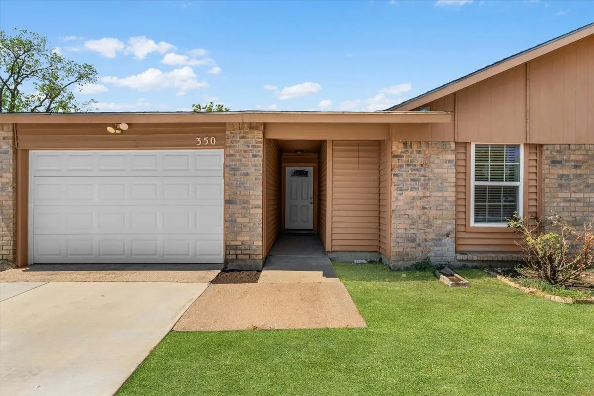 Brick and siding exterior with a single-panel garage door, covered entry, and pitched roof