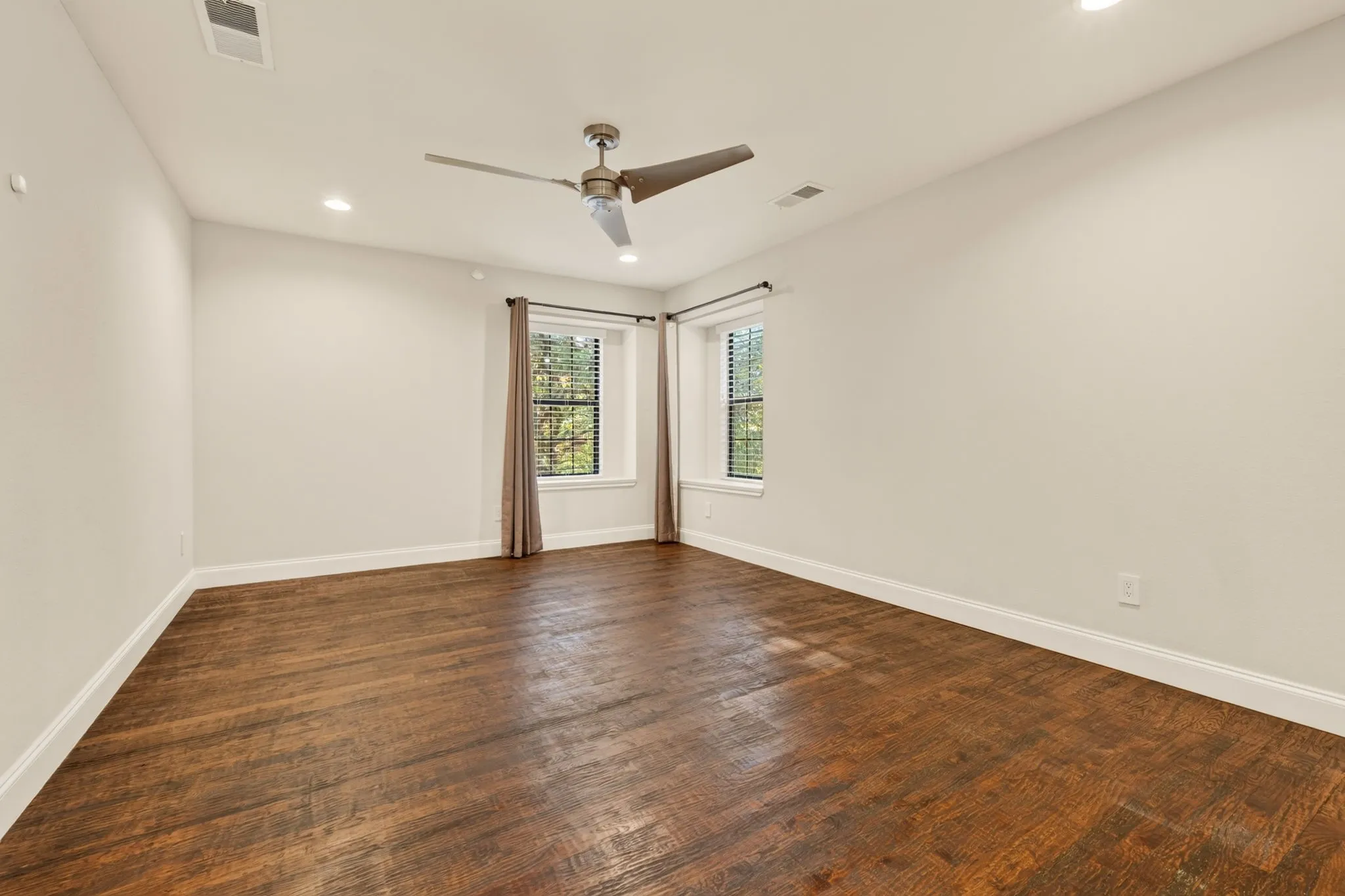 Upstairs Bedroom with Wood flooring, recessed lighting, ceiling fan, and two windows with blinds