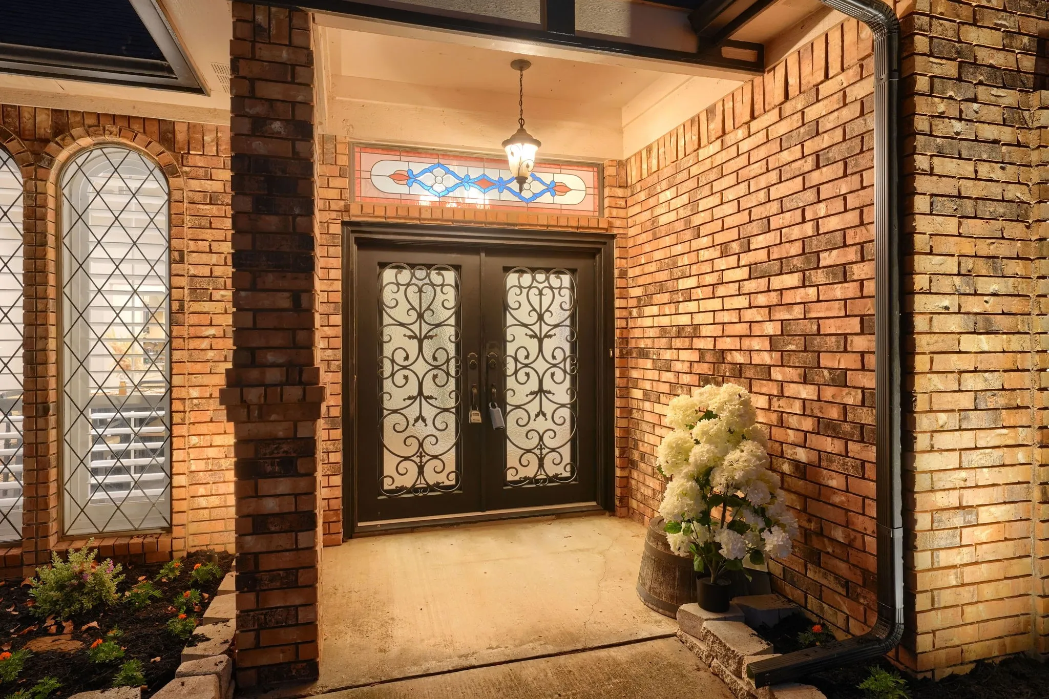 Brick exterior with arched windows, decorative double entry doors, and an ornate transom window