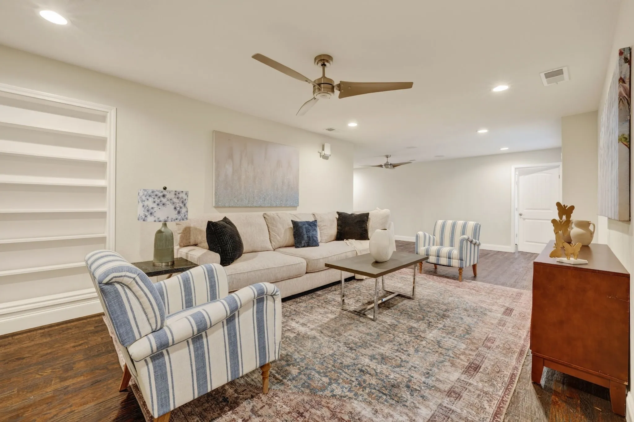 Upstairs Spacious living area featuring wood-finish flooring, recessed lighting, and built-in shelving