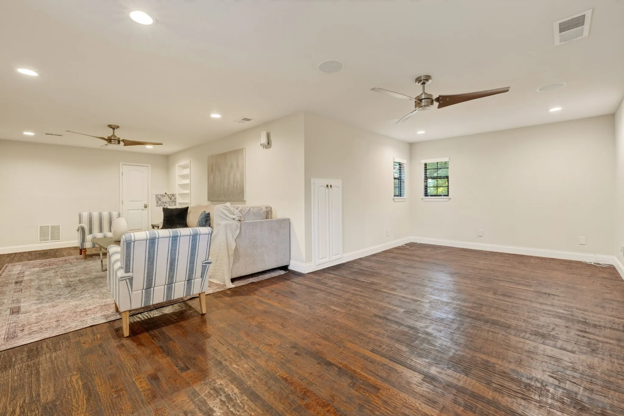 Flex space featuring rich wood flooring, recessed lighting and ceiling fans