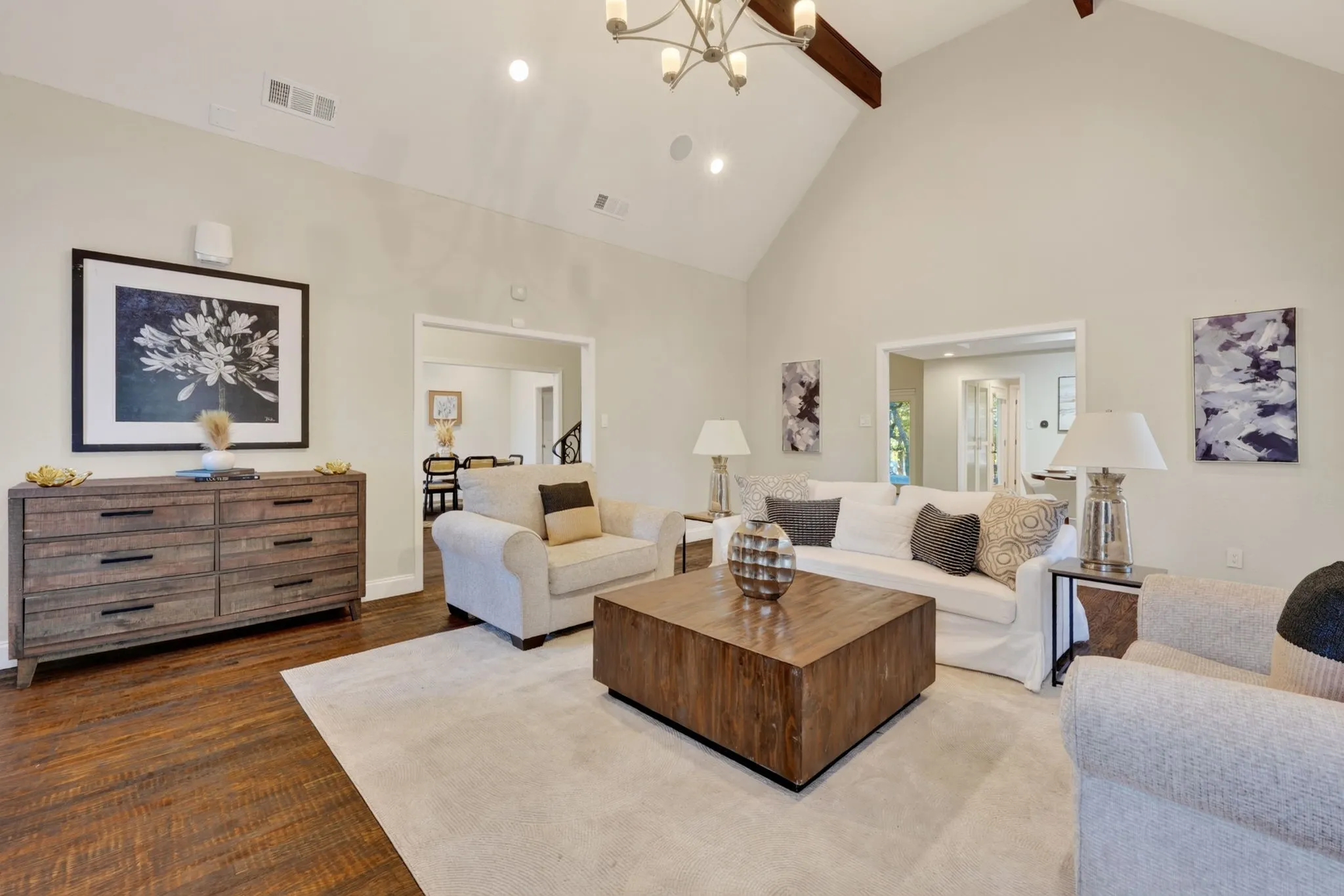 Vaulted ceiling with exposed wood beams, wood-finish flooring, recessed lighting, and a chandelier