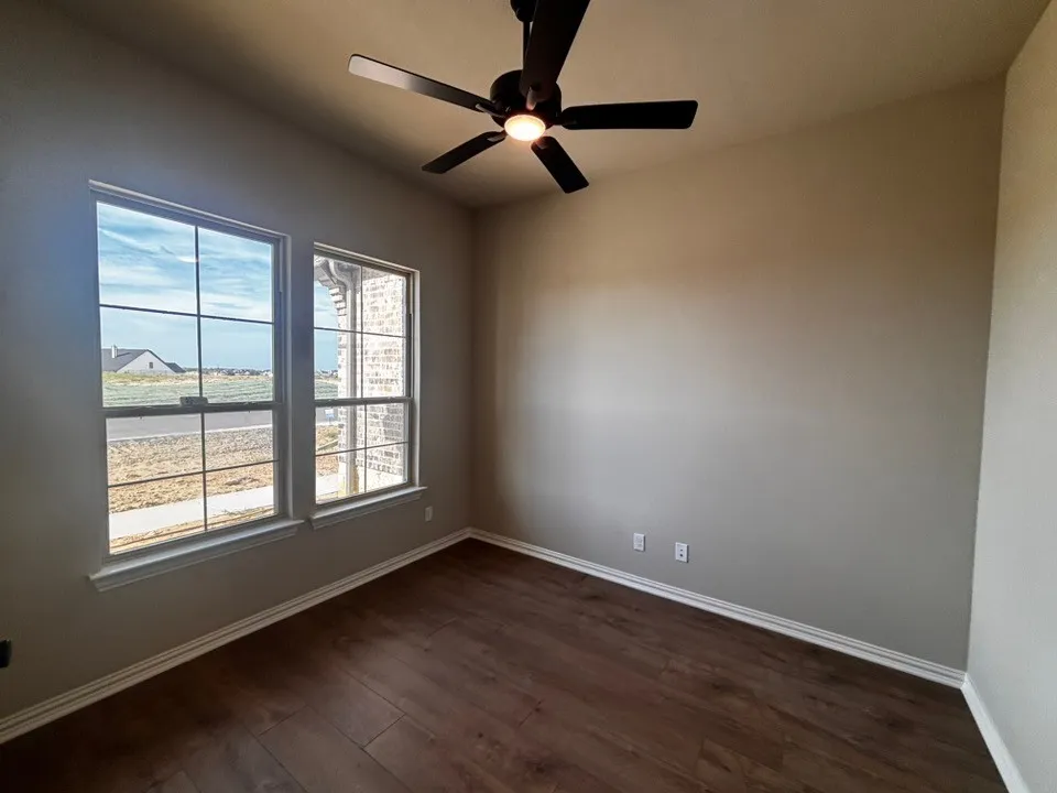 Wood-finish flooring, dual windows, and ceiling fan with integrated lighting