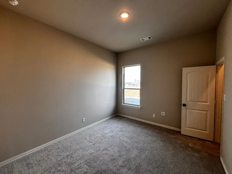 Neutral-toned walls, recessed ceiling lighting, and light-colored carpeting