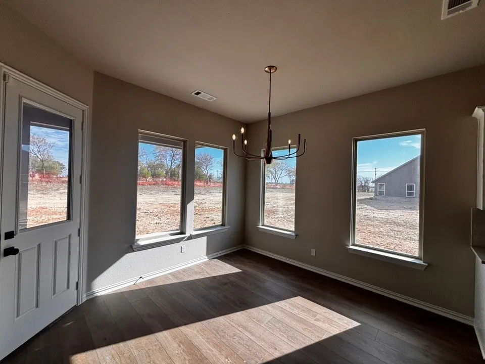 Recessed ceiling, wood-finish flooring, multiple windows, contemporary chandelier, white paneled door with glass​​‌​​​​‌​​‌‌​‌‌​​​‌‌​‌​‌​‌​​​‌​​ insert