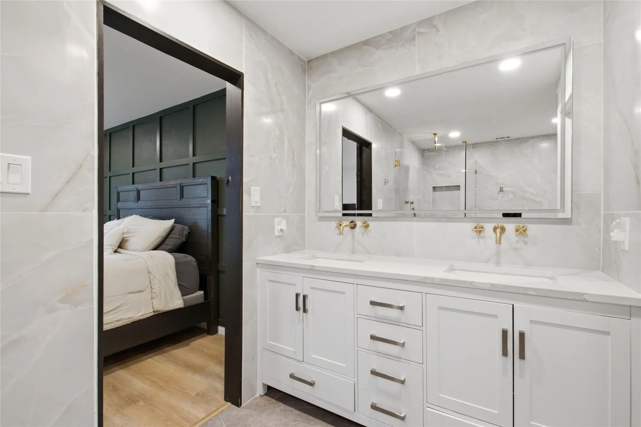 Contemporary bathroom featuring a dual vanity with white shaker-style cabinetry and a light-toned countertop