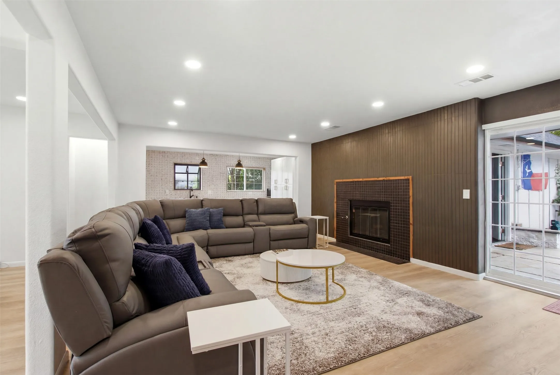 Spacious living area featuring light wood-finish flooring and recessed lighting