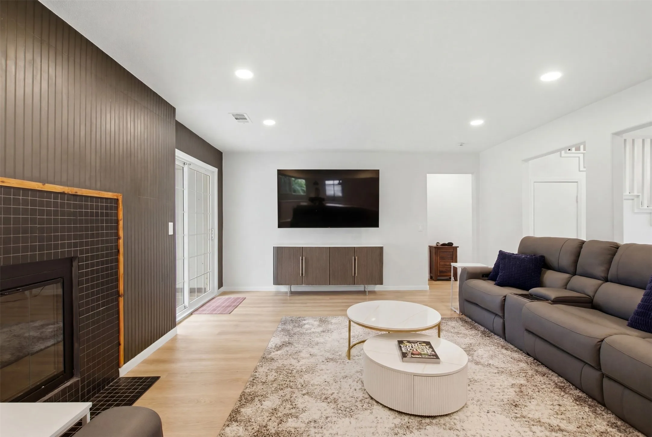 Living area featuring wood-finish flooring and recessed lighting