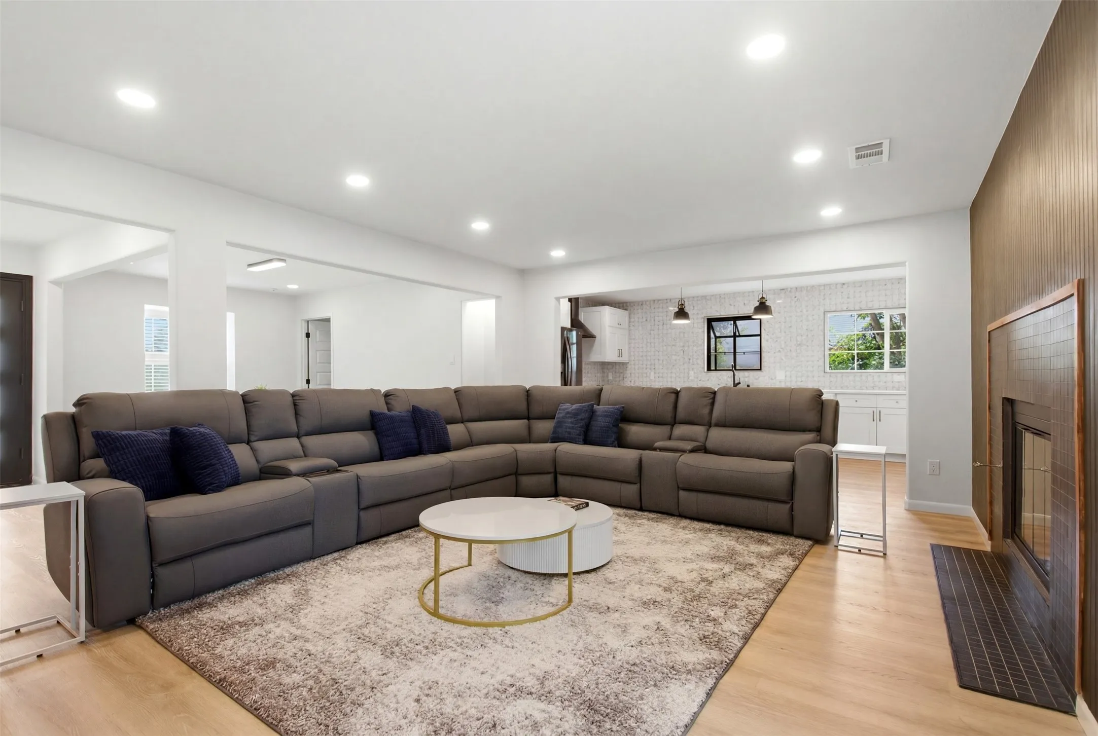 Expansive open-concept living area featuring light wood-finish flooring and recessed lighting