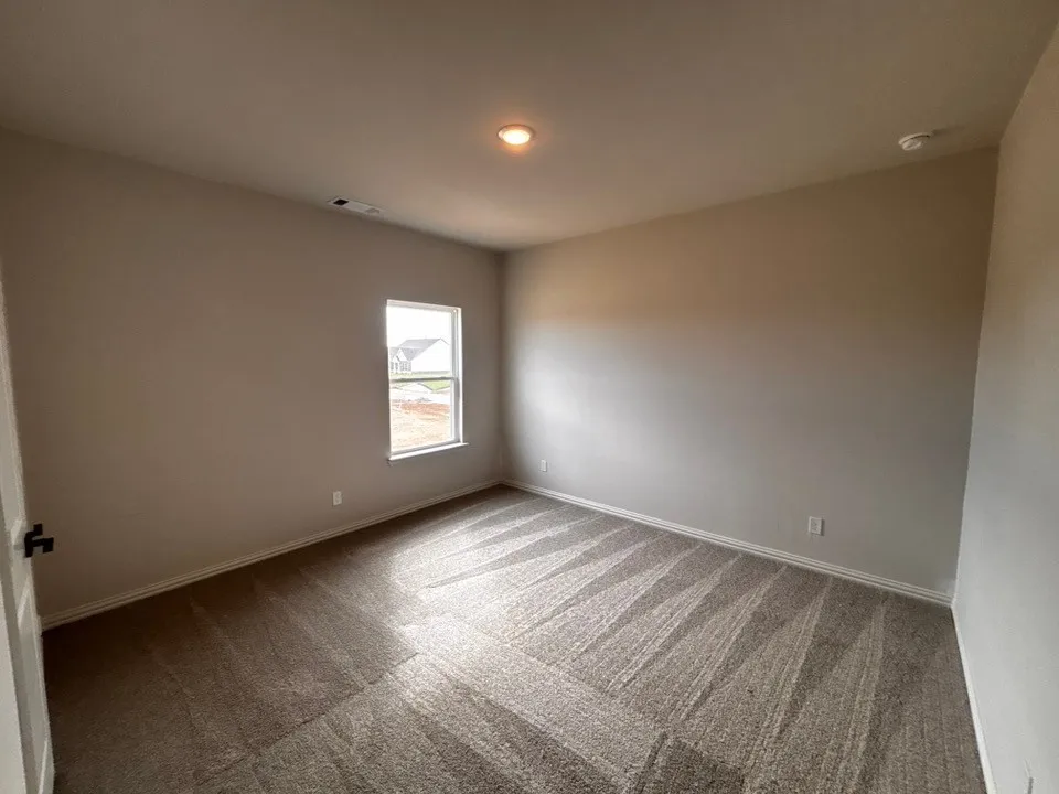 Recessed ceiling light, neutral wall palette, window with exterior exposure, textured carpeting, and white trim