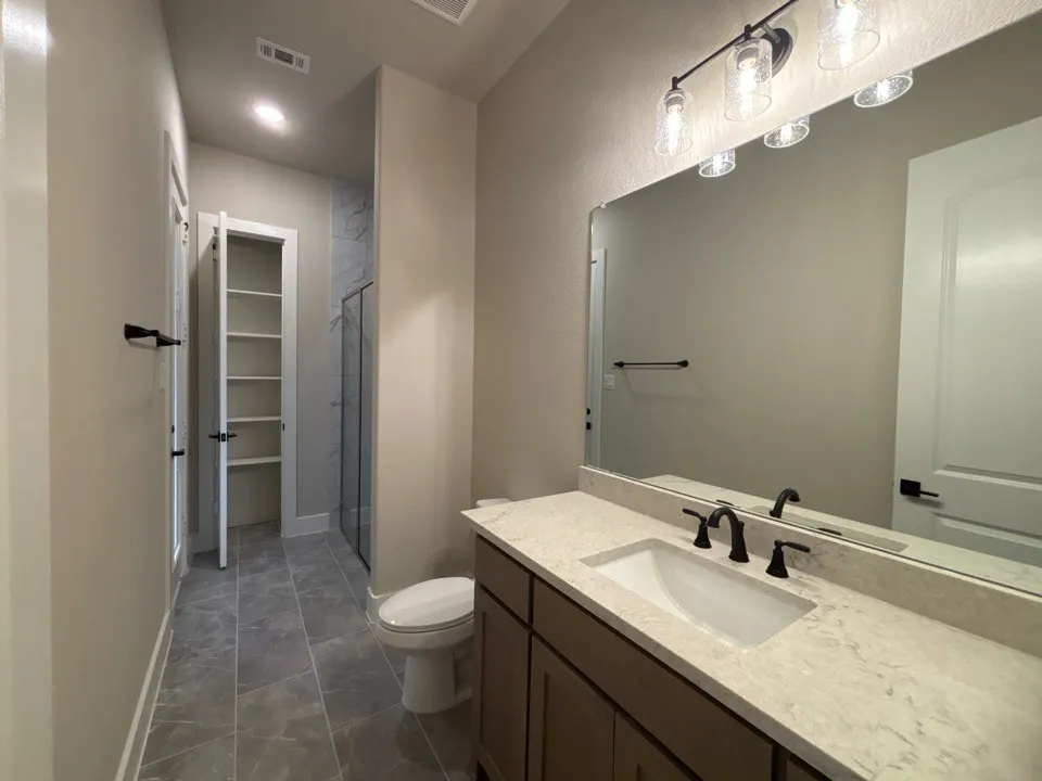 Modern vanity with an integrated sink, light-toned countertop, and matte black fixtures