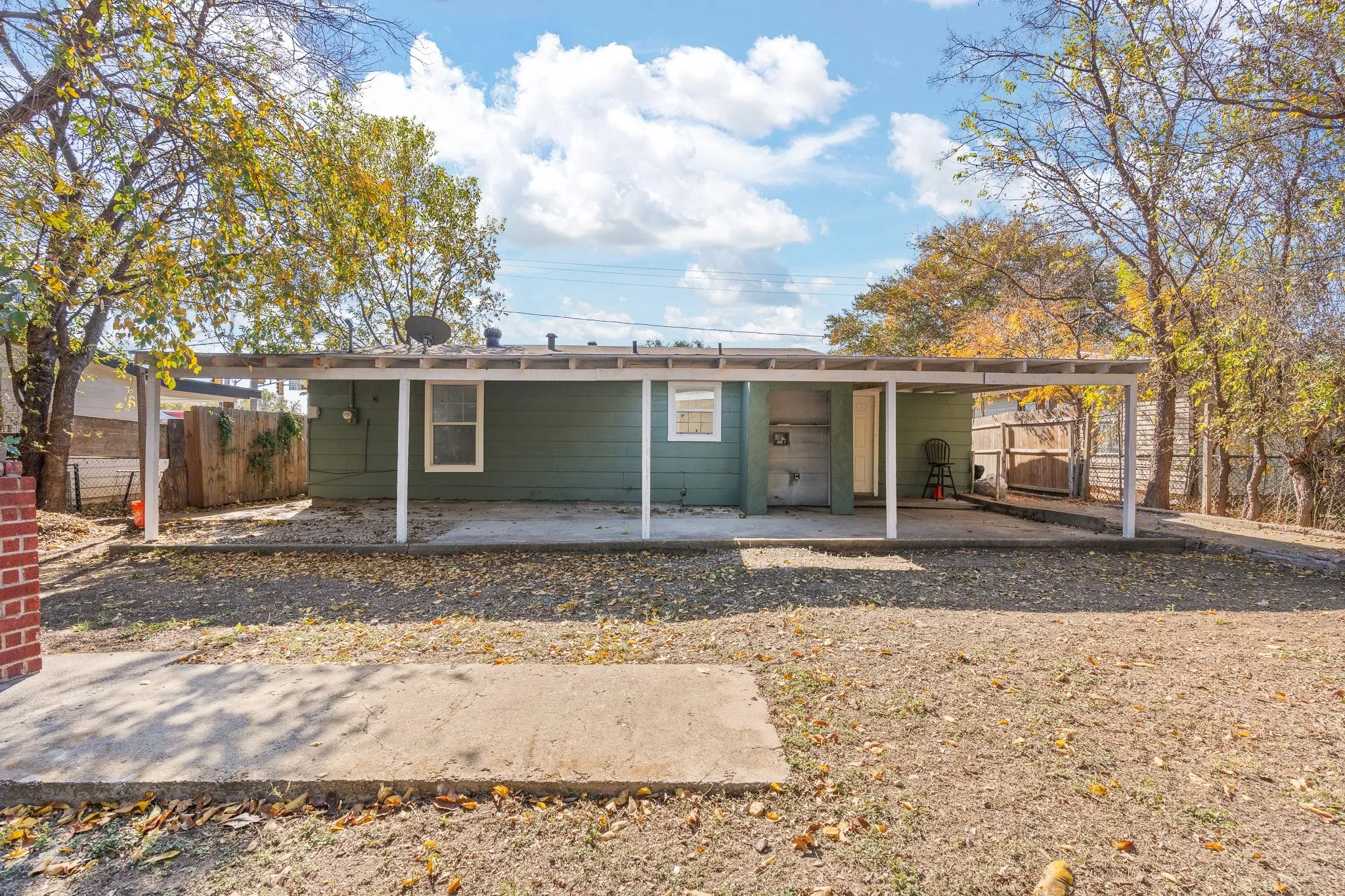 Backyard featuring a covered patio, concrete slab, and wood privacy fencing