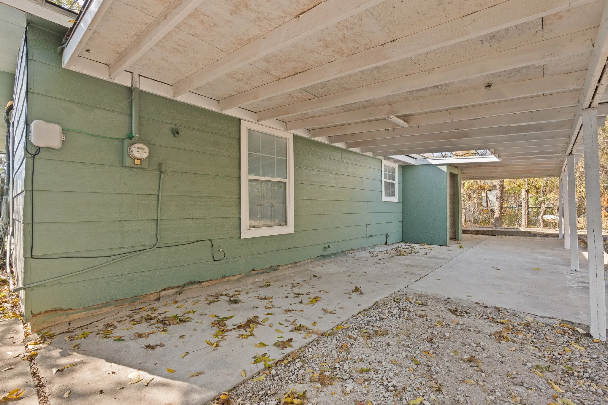 Covered concrete patio with exposed wood ceiling beams