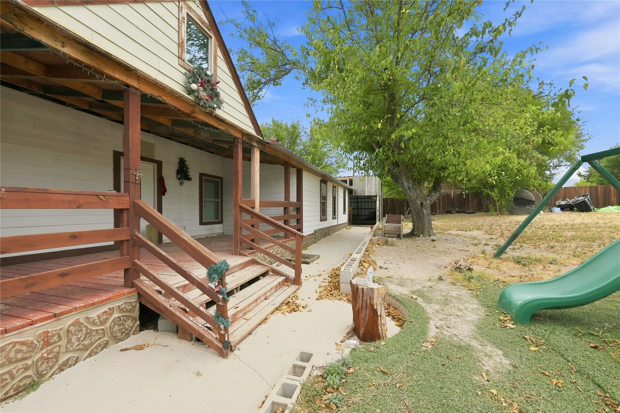 Exterior with an expansive covered porch featuring wood railing