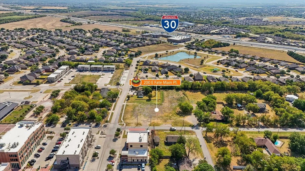 Aerial perspective highlighting a large undeveloped lot, surrounded by established residential areas and commercial structures