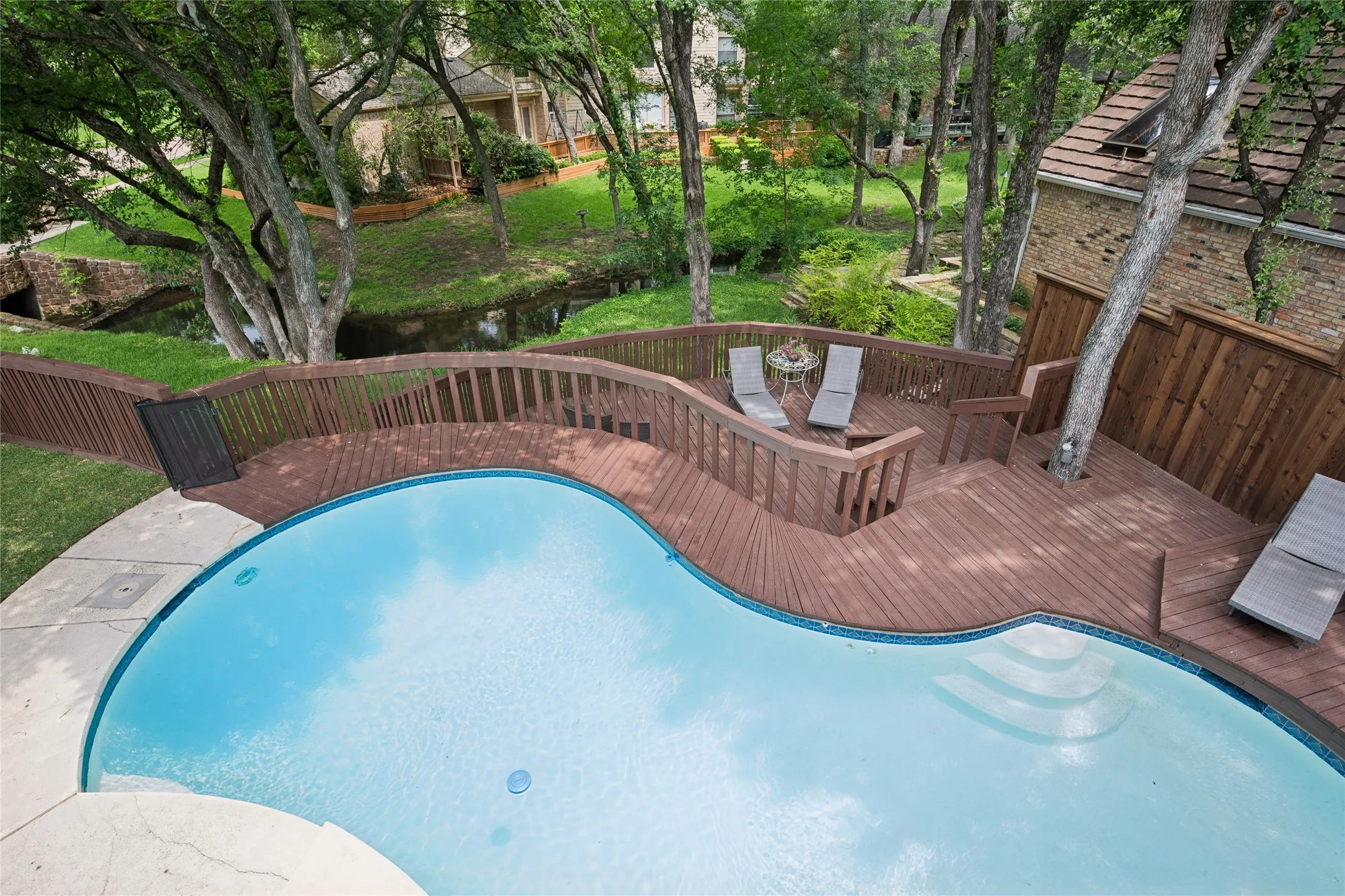 Woodsy paradise on the creek with shaded two tier deck. Pool comes with safety fence to protect little ones.