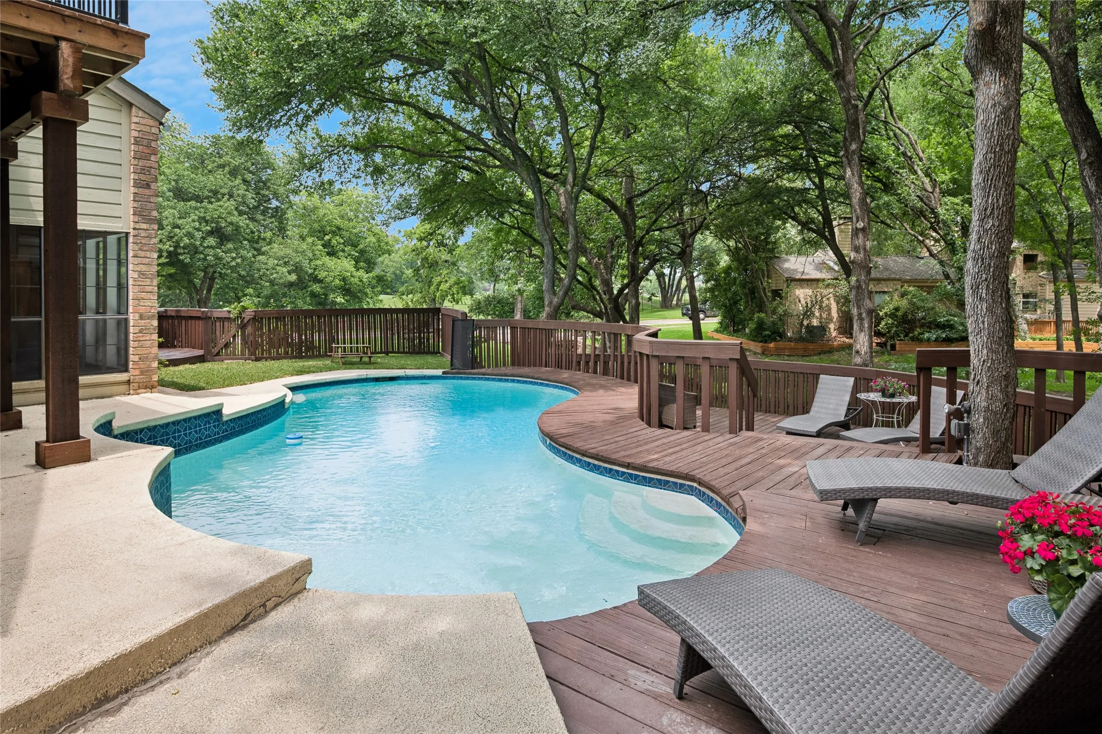 Come relax beside still waters around this custom two-tiered deck beneath shade trees.